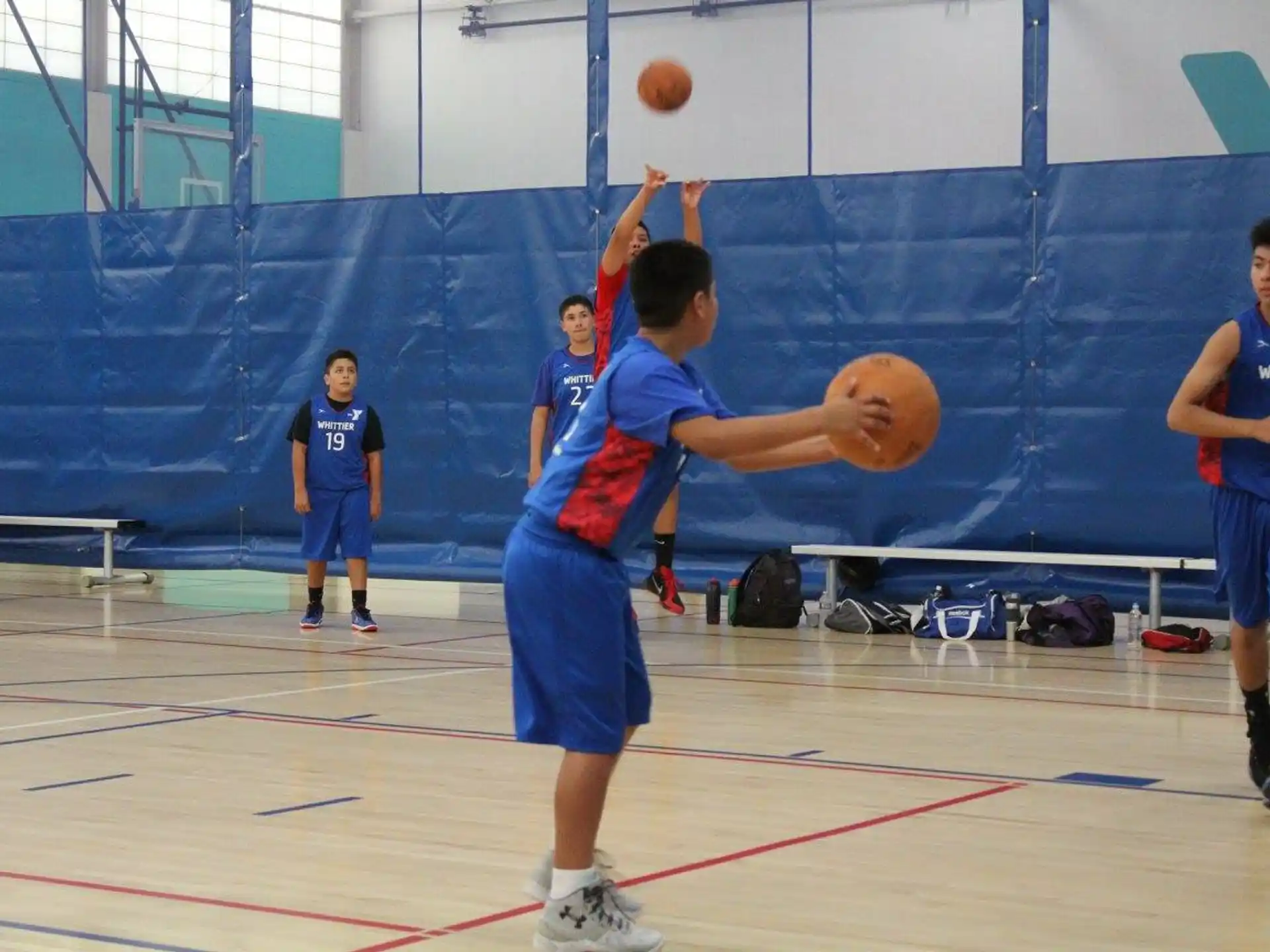 a group of kids playing basketball