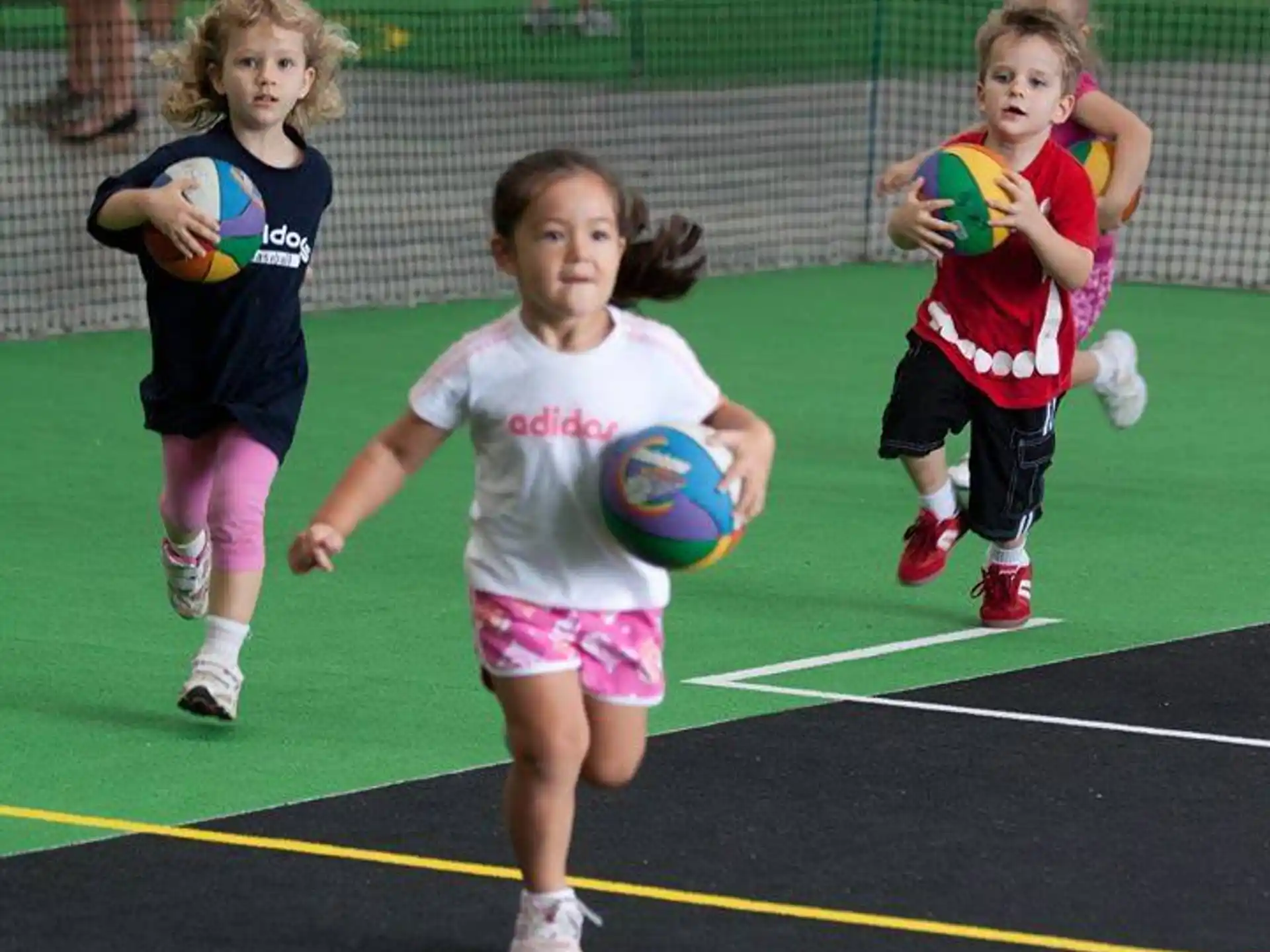a group of girls playing with a ball on a field