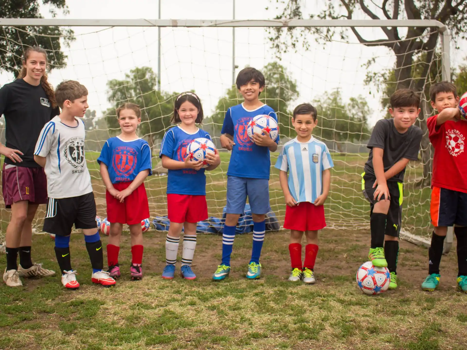 a group of kids standing in front of a goal