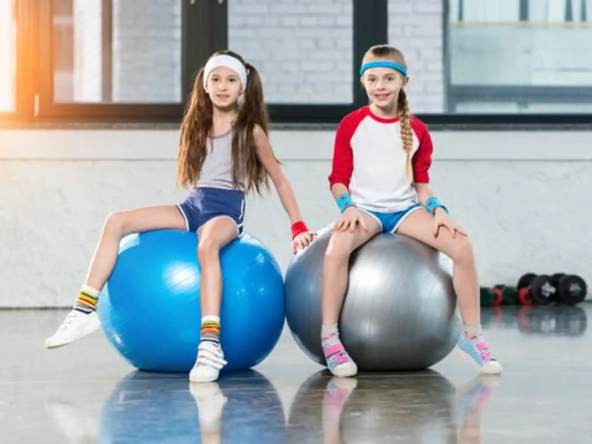 two girls sitting on balls