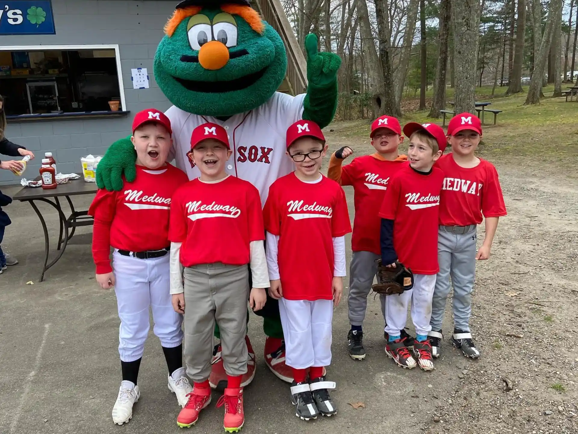a group of kids wearing red shirts and hats