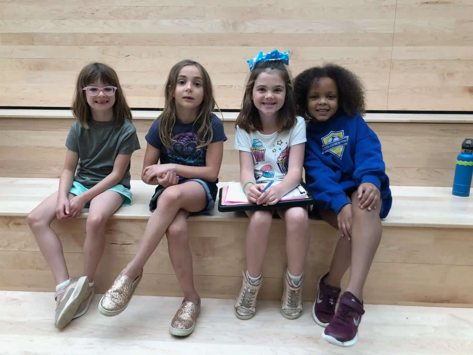 a group of girls sitting on a bench