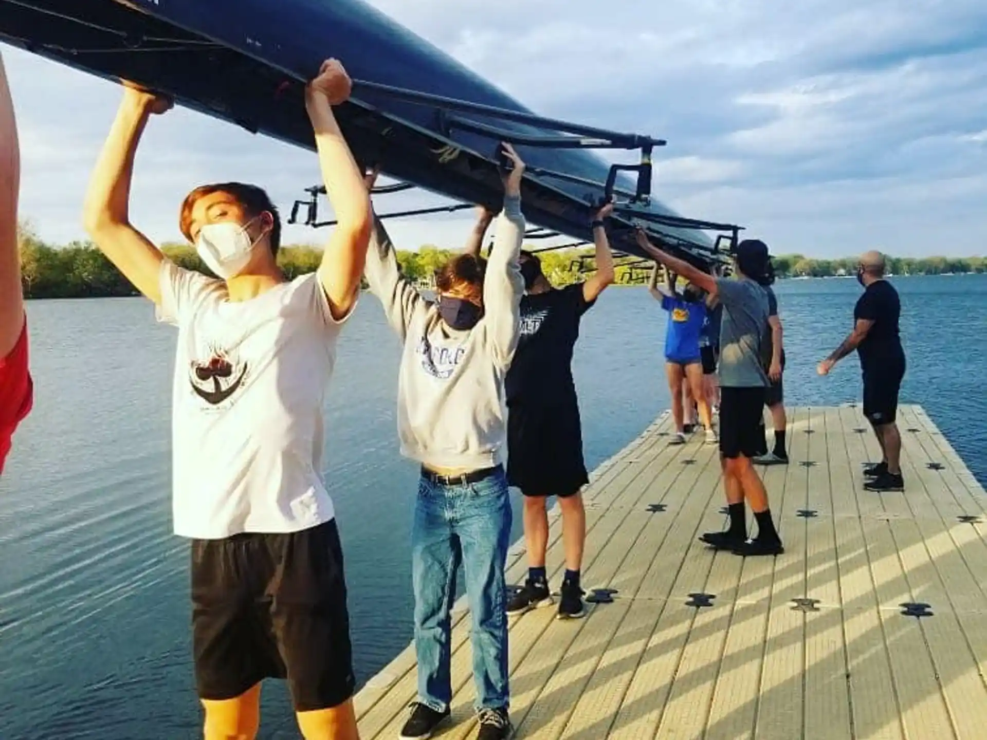 a group of people holding a large black object on a dock