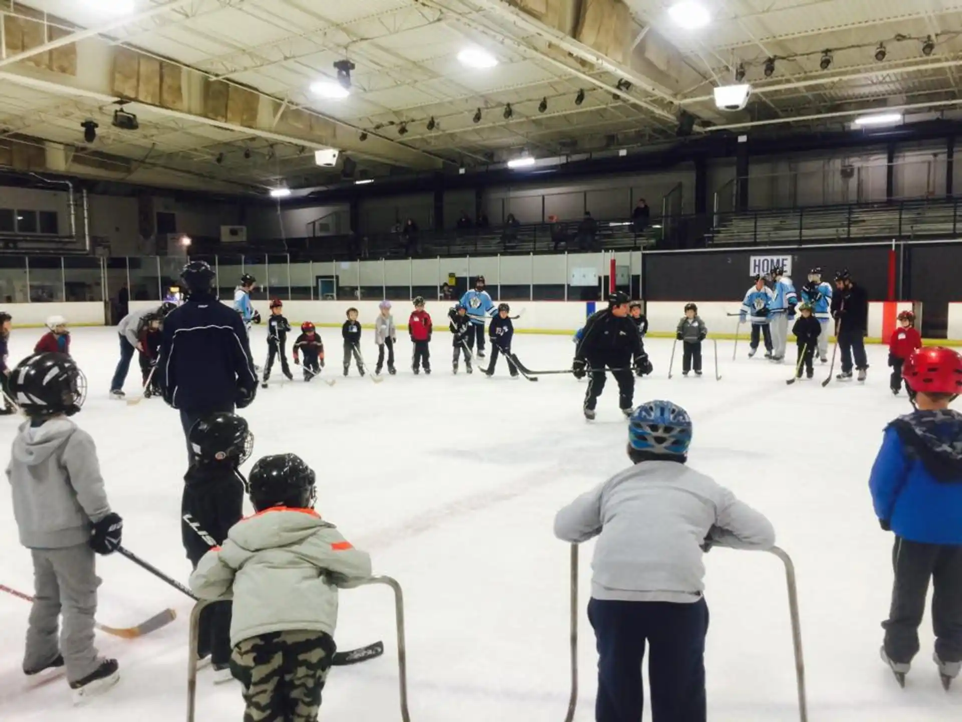 a group of people on an ice rink with hockey sticks
