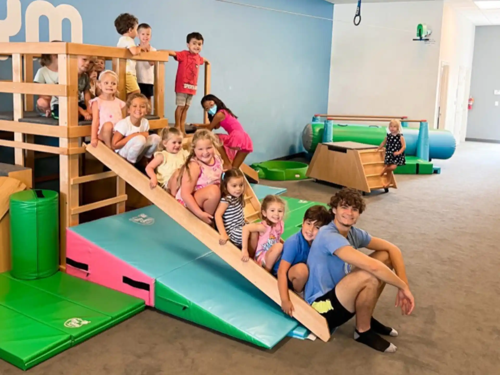 a group of children sitting on a mat in a room