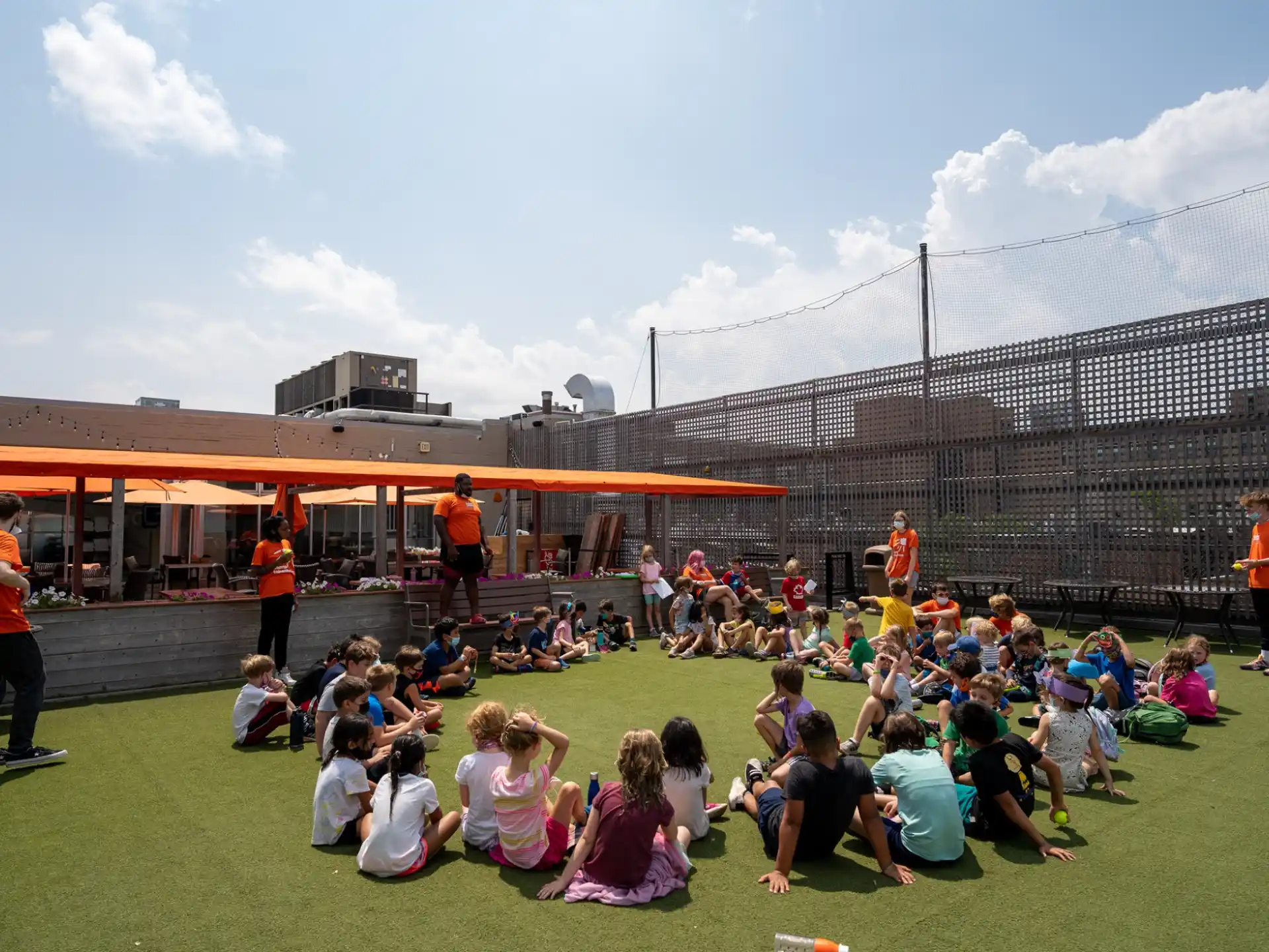 a group of people sitting on the grass in front of a stadium
