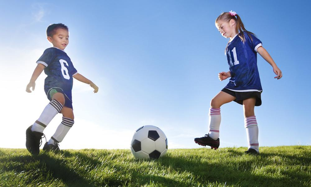 a boy and girl playing football