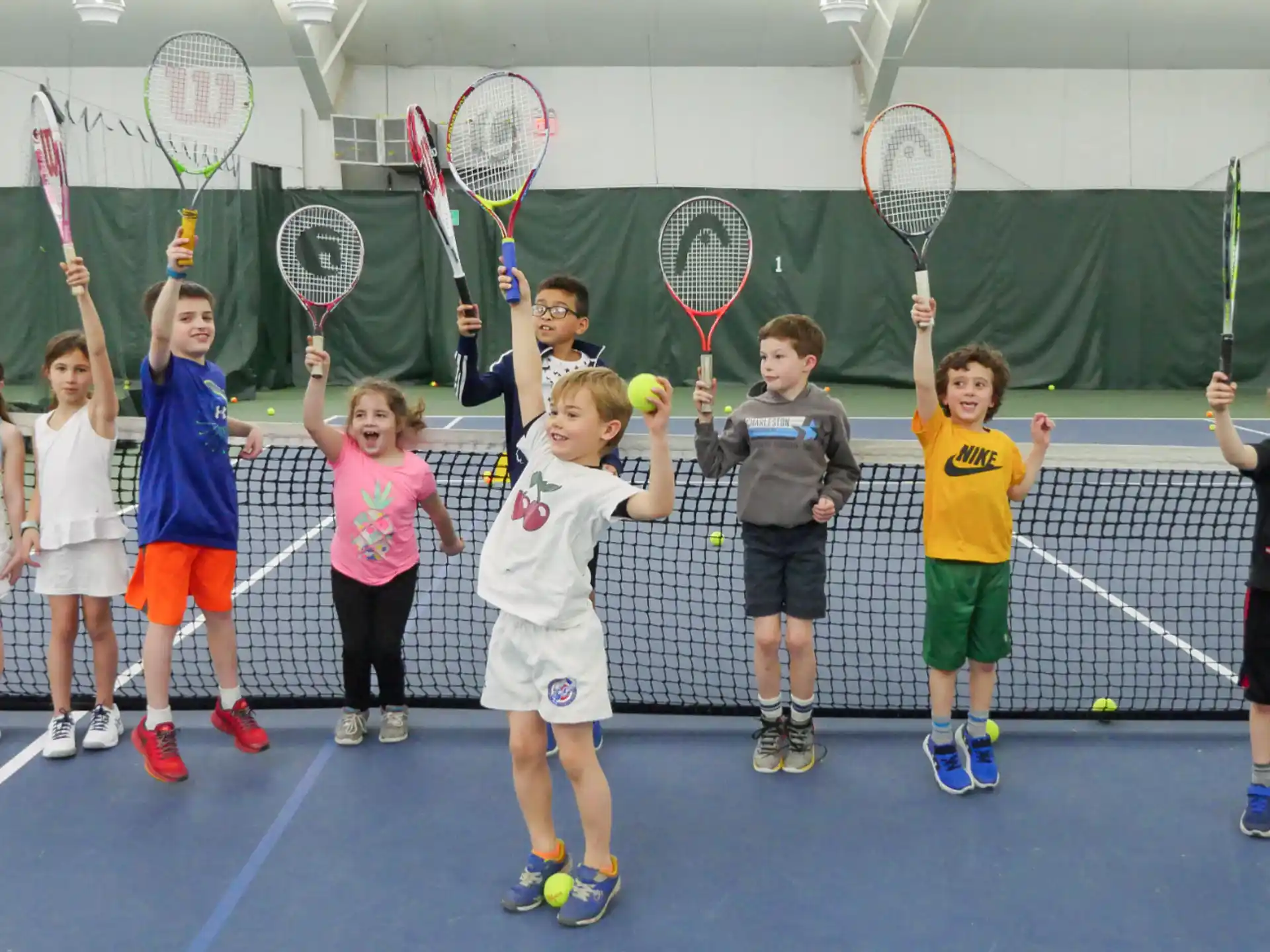 a group of kids holding tennis rackets