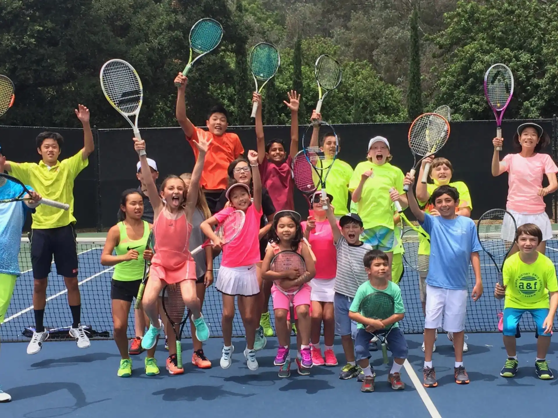 a group of kids holding tennis rackets