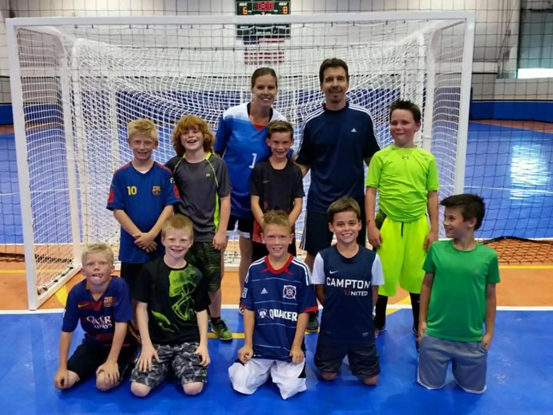 a group of people posing for a photo in front of a goal