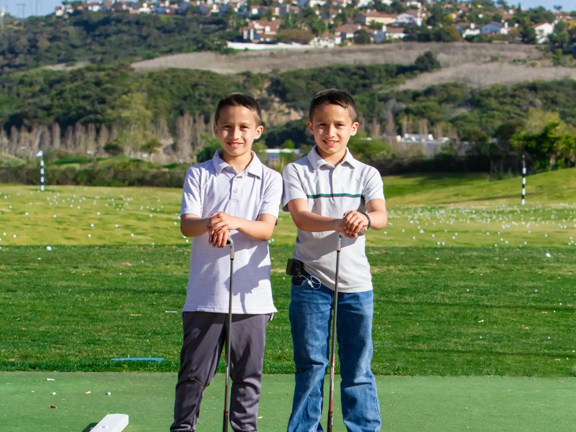 two boys standing on a golf course
