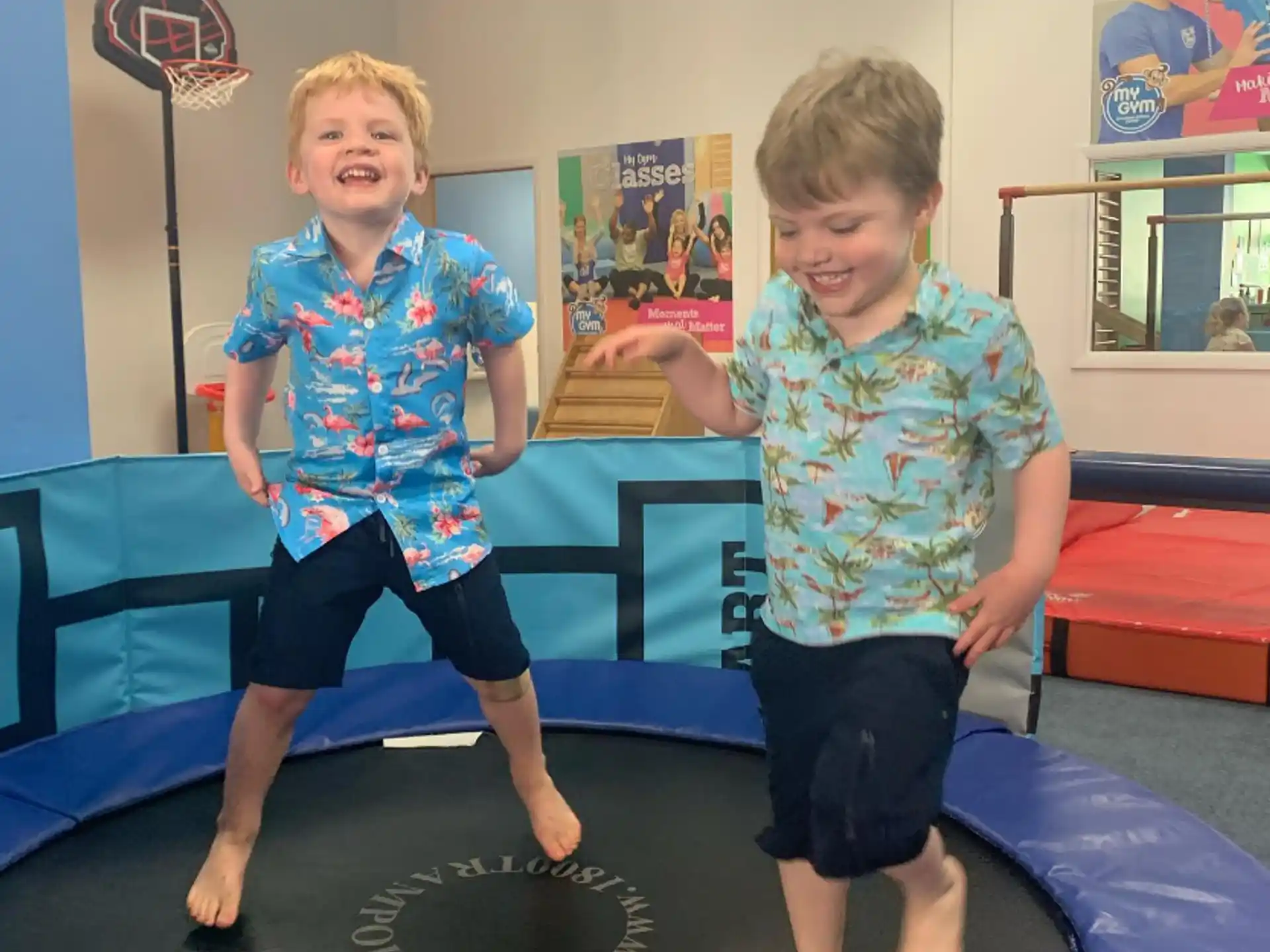 a couple of children jumping on a mat