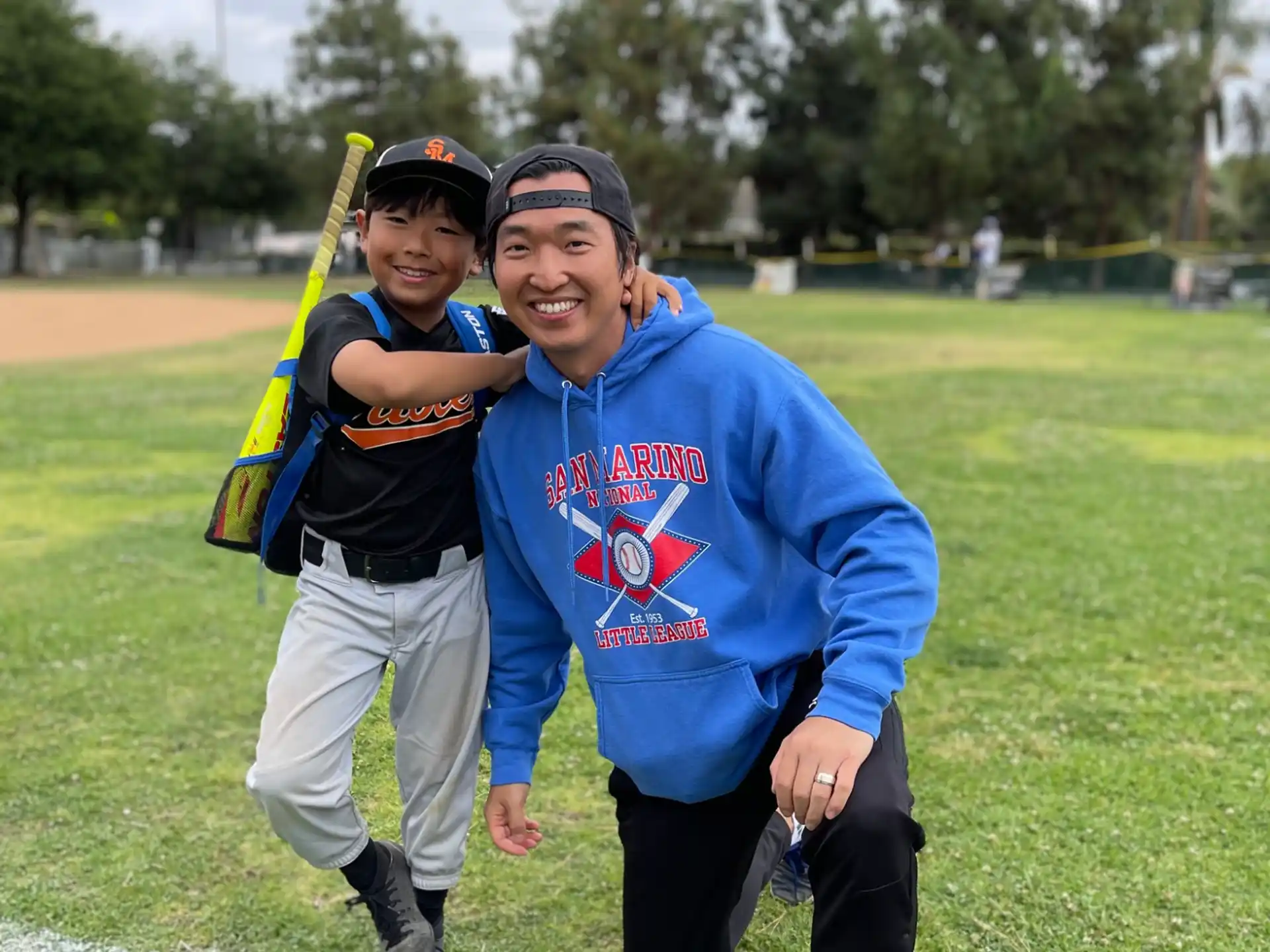 a person and a boy posing for a picture on a grass field