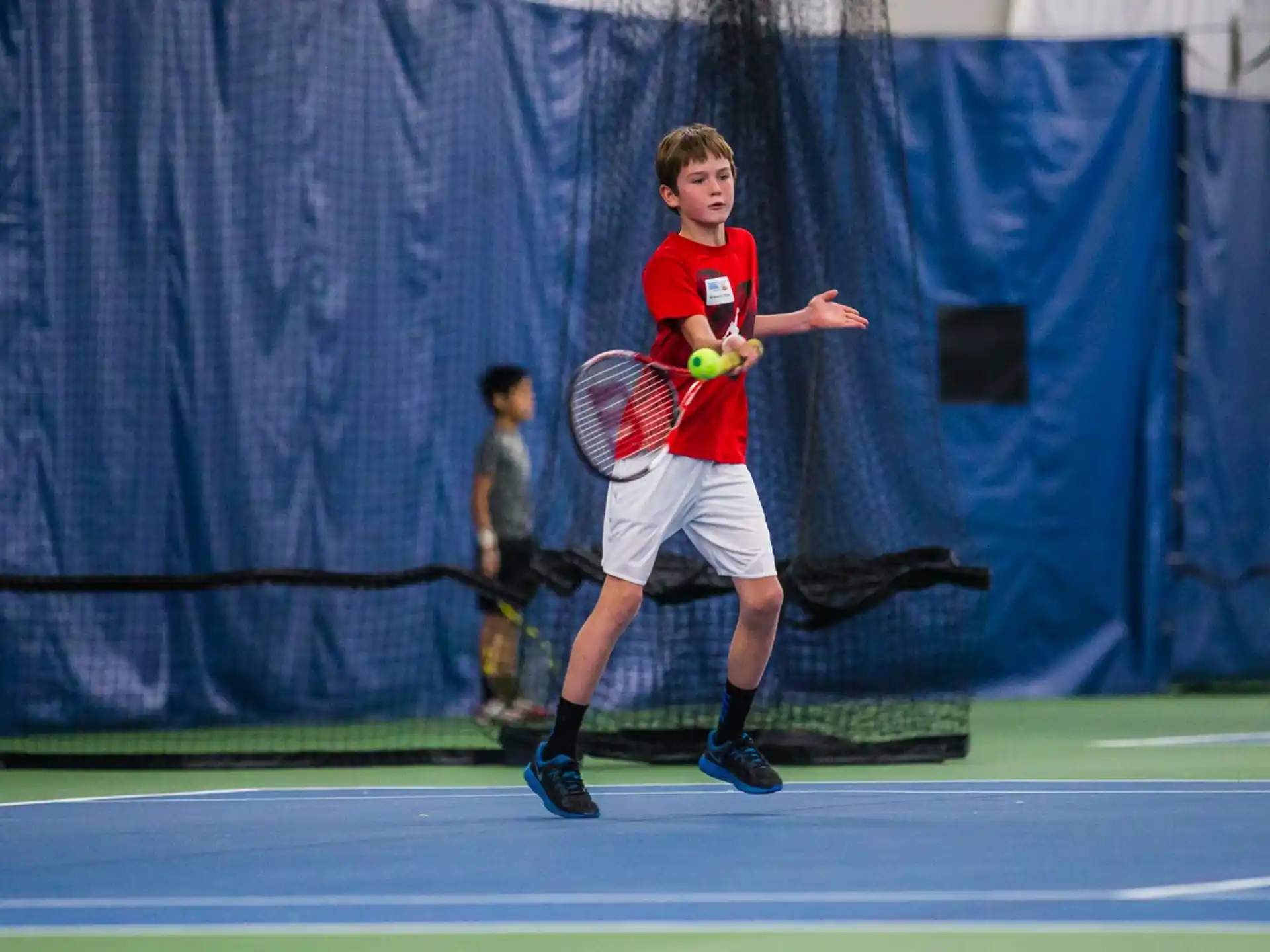 a man holding a tennis racket and a ball
