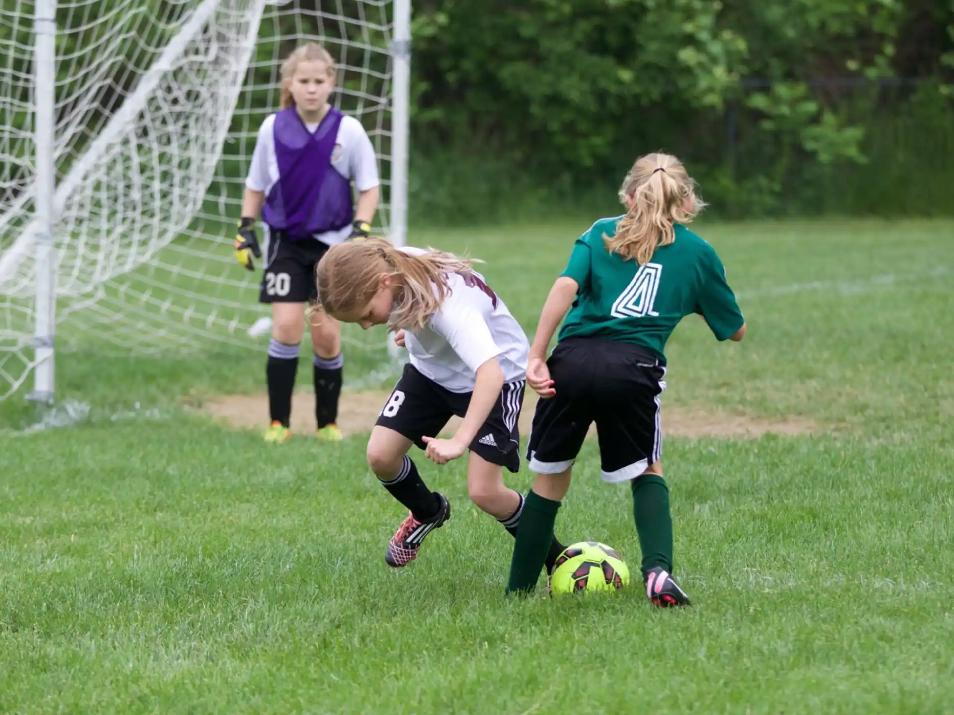 girls playing football on a field