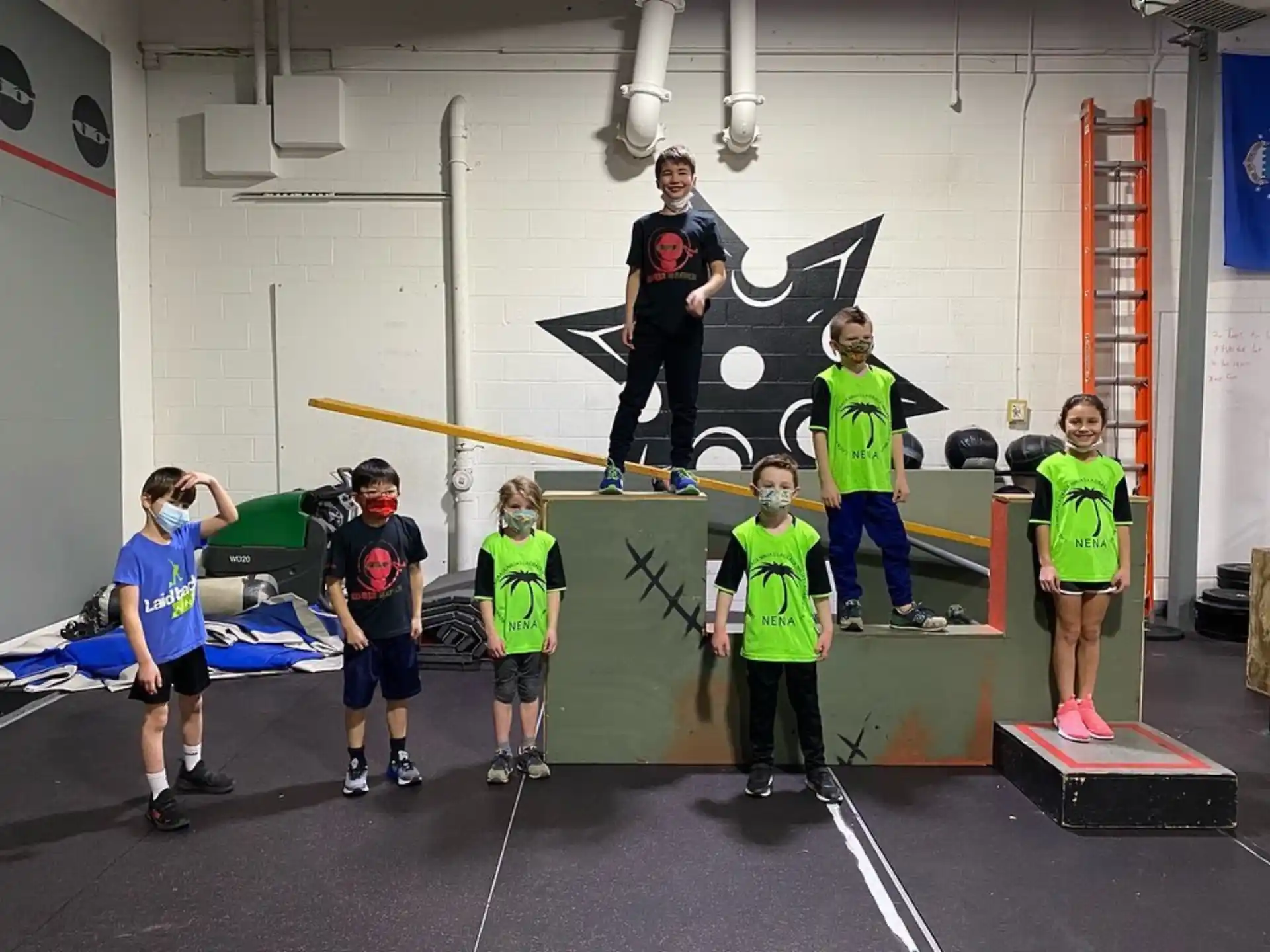 a group of people standing on a mat in a gym