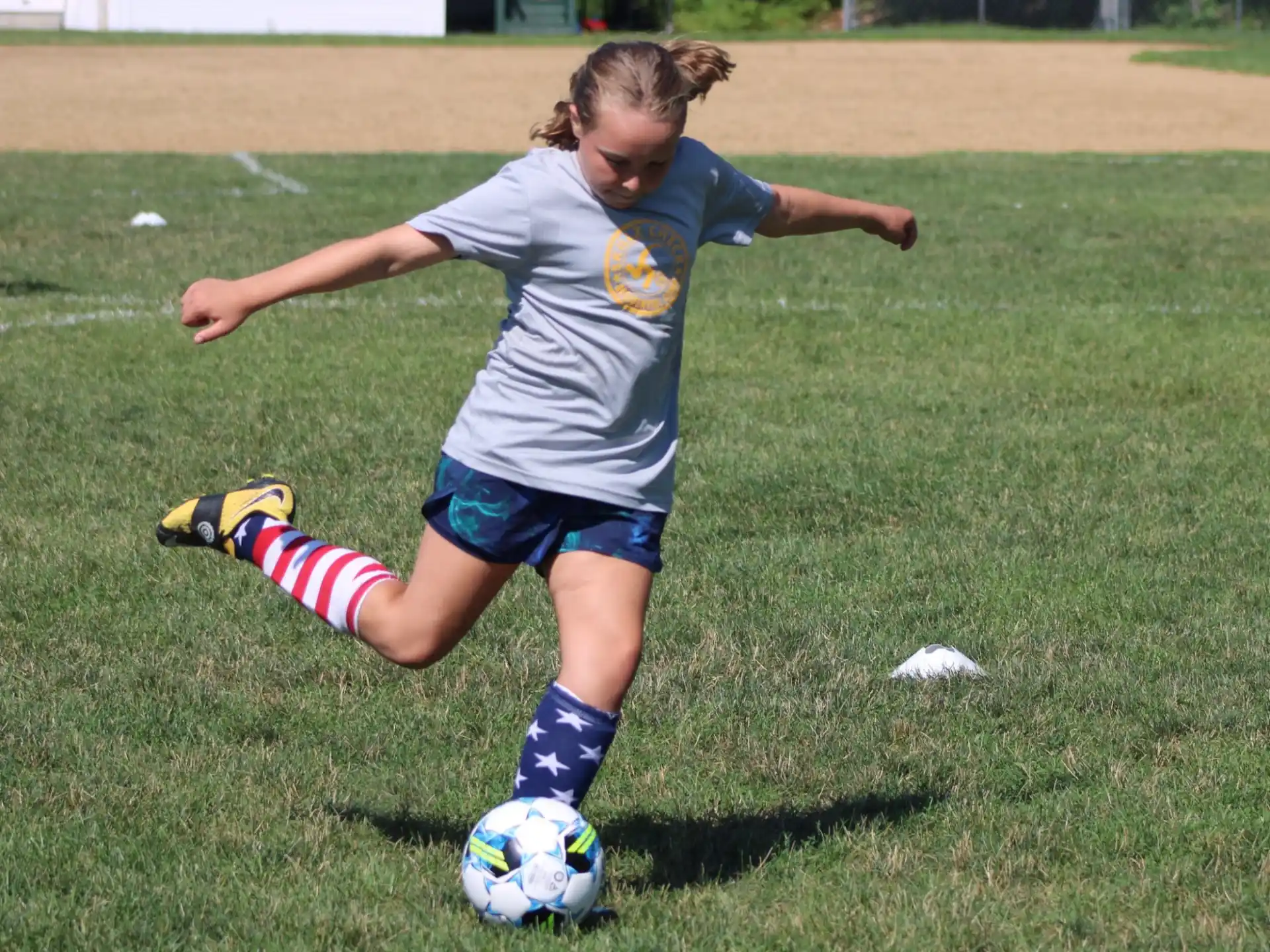 a girl kicking a football ball