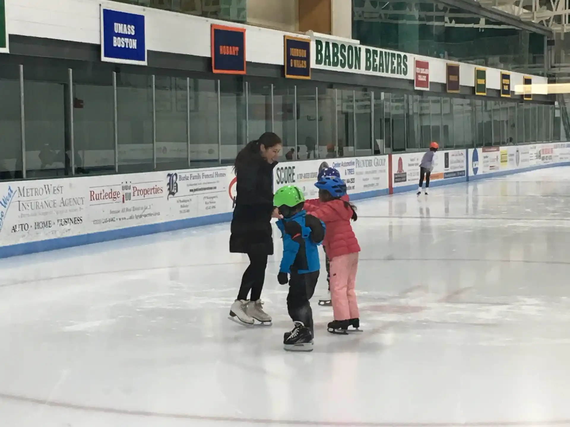 a person and two children on an ice rink