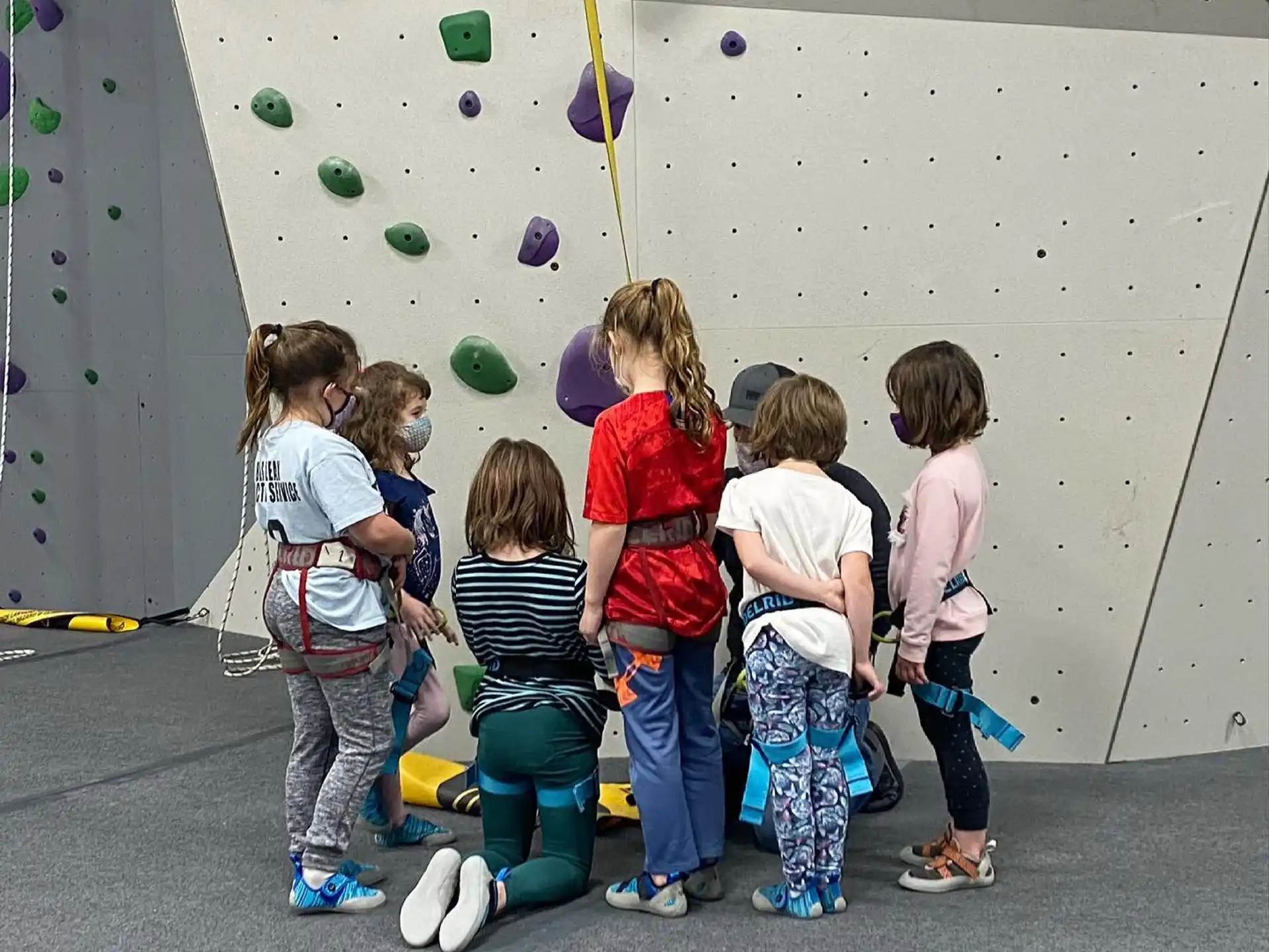 a group of children standing in front of a wall with balloons