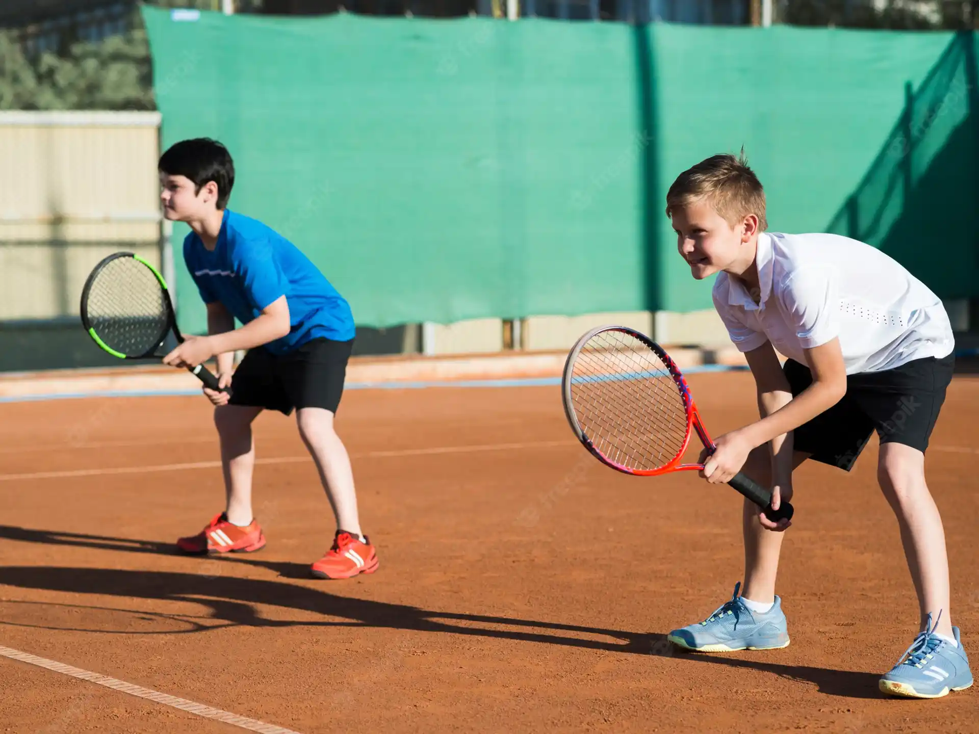 a couple of boys playing tennis