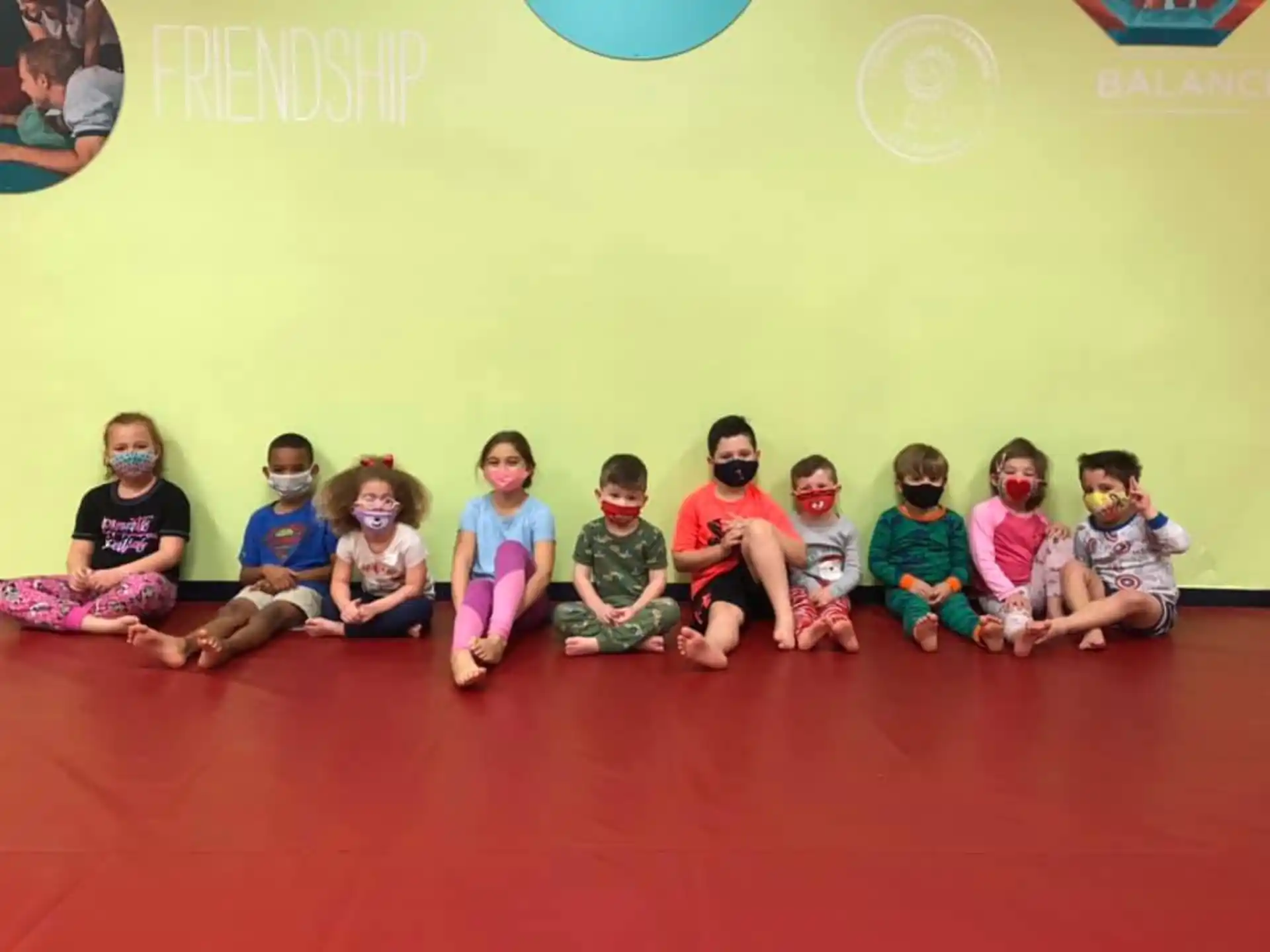 a group of children sitting on the floor posing for the camera