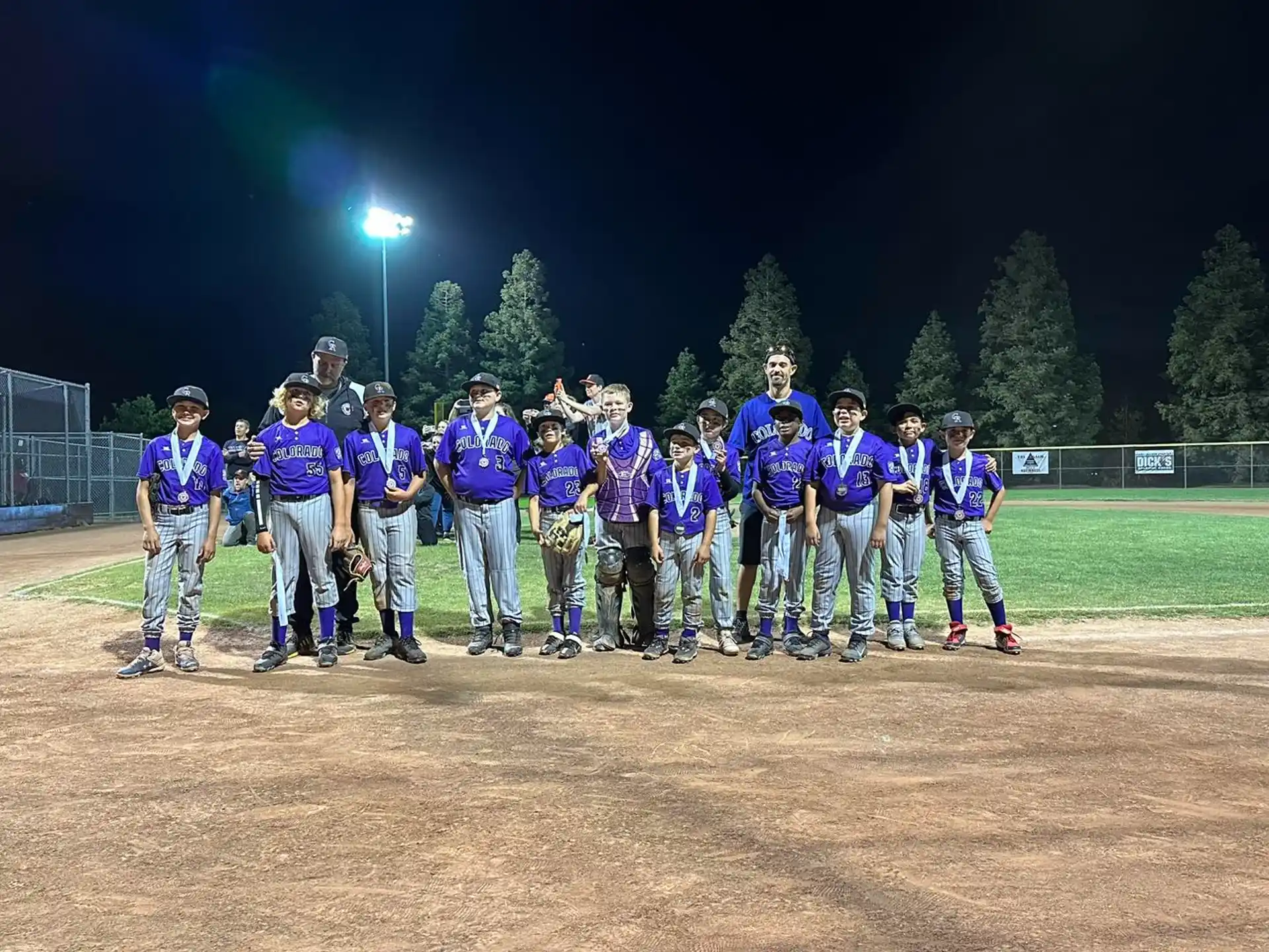 a group of people in uniform standing on a field at night