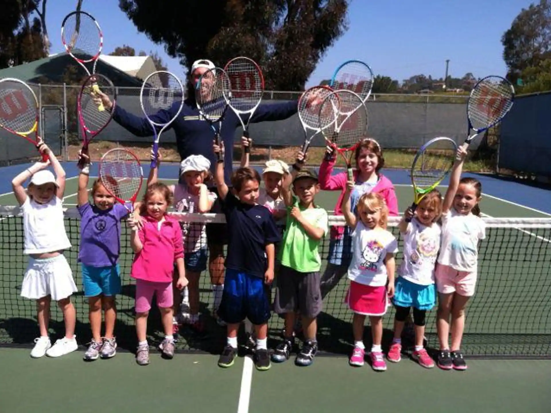 a group of kids holding tennis rackets