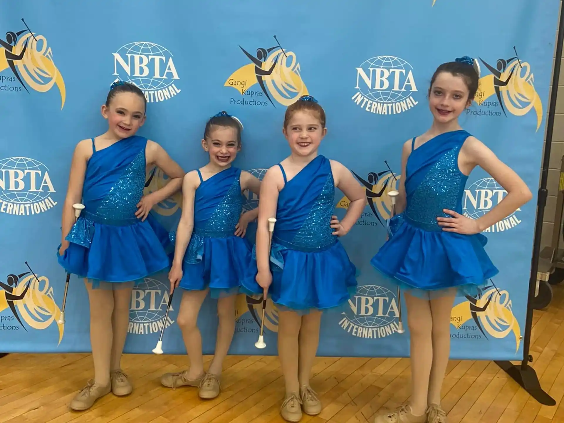 a group of girls in blue dresses