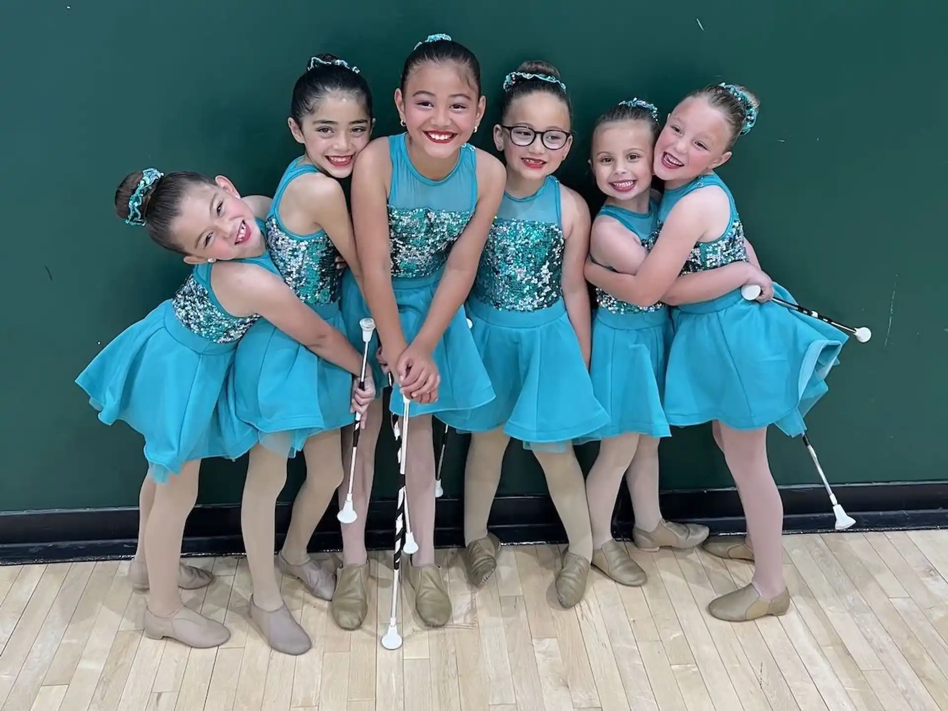 a group of girls in blue dresses