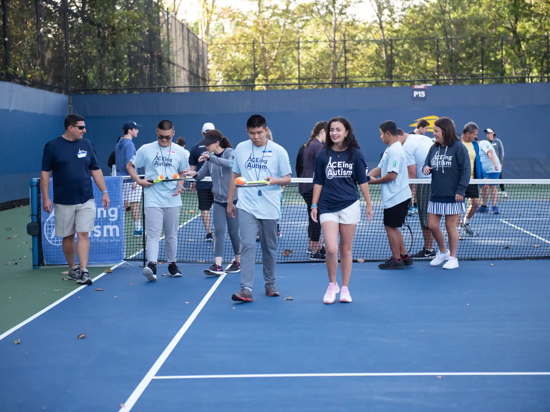 a group of people standing on a tennis court