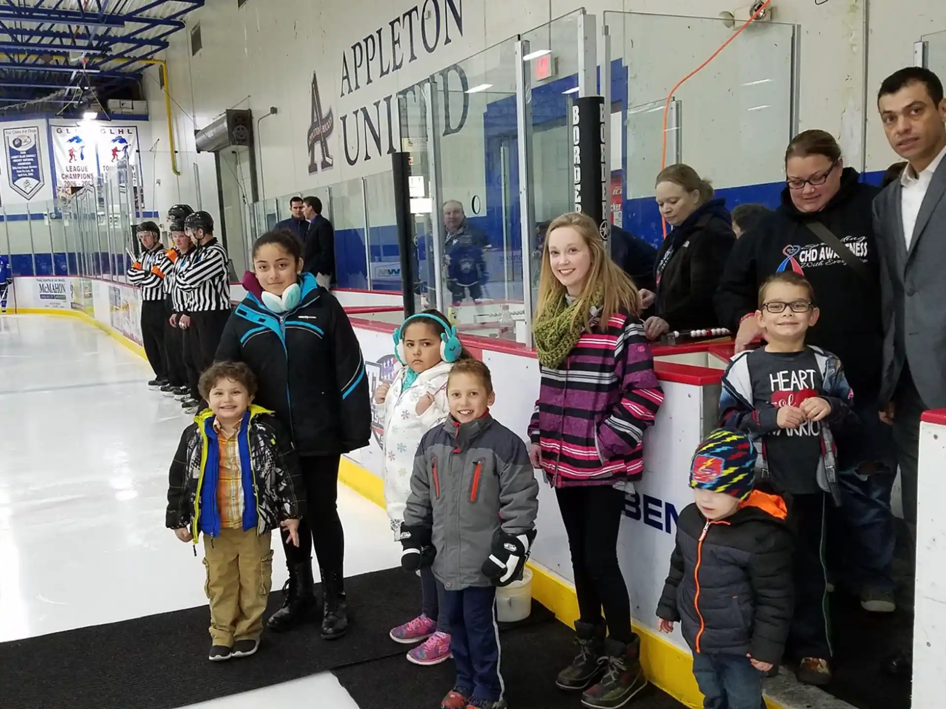 a group of people standing on an ice rink