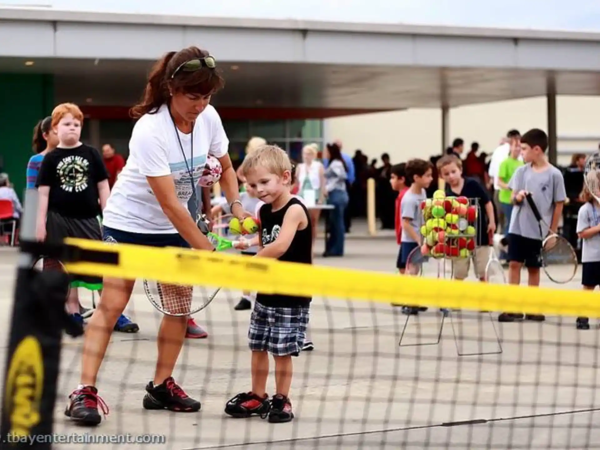 a person and a couple of kids playing tennis