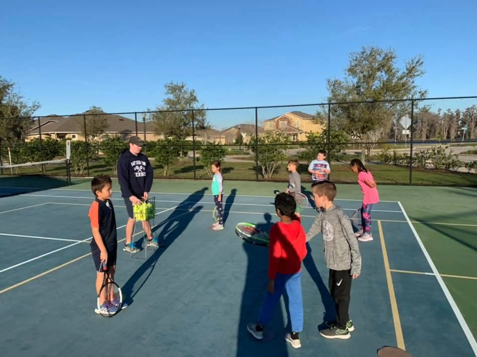 a group of kids playing tennis