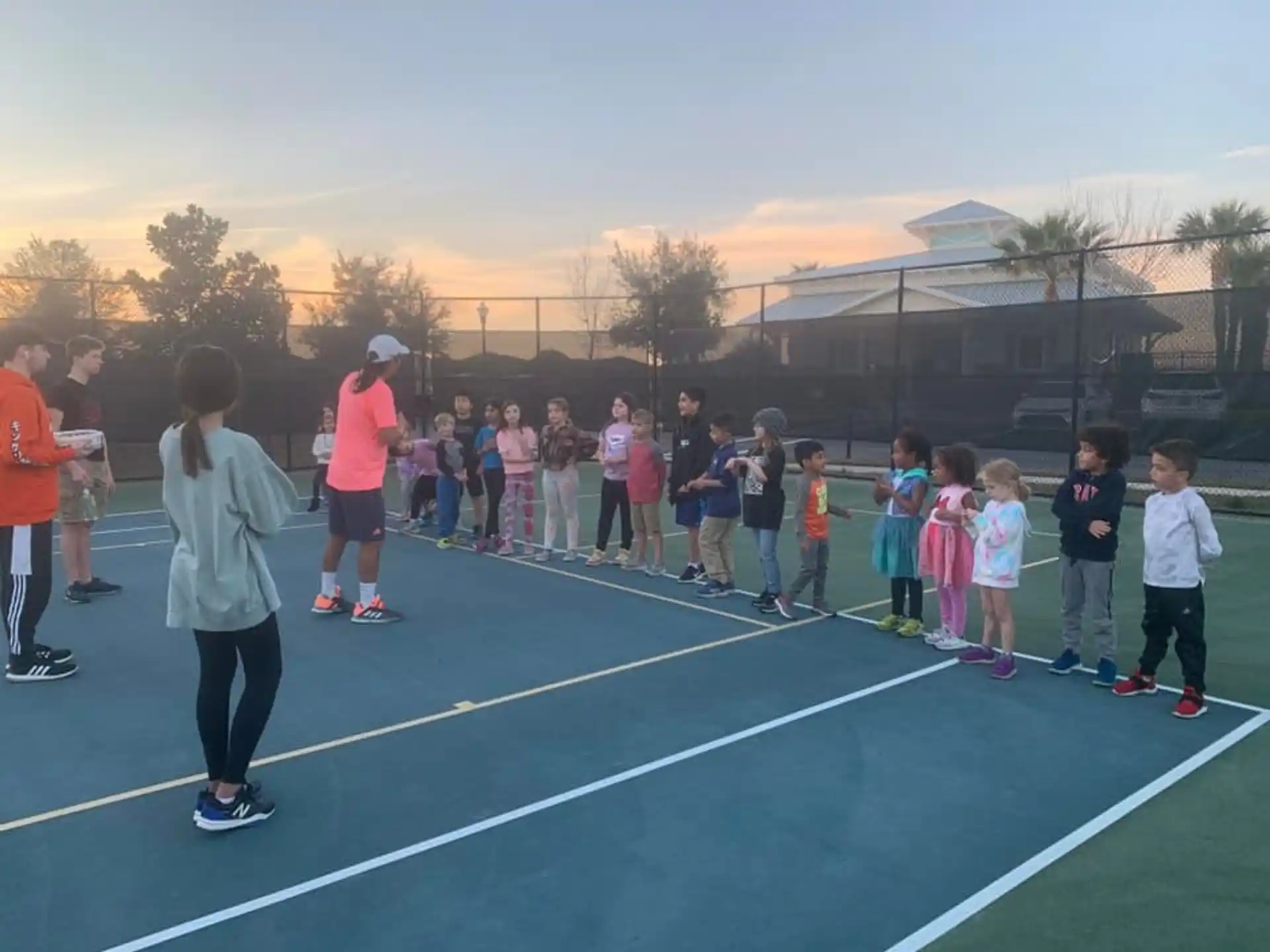 a group of people standing on a tennis court