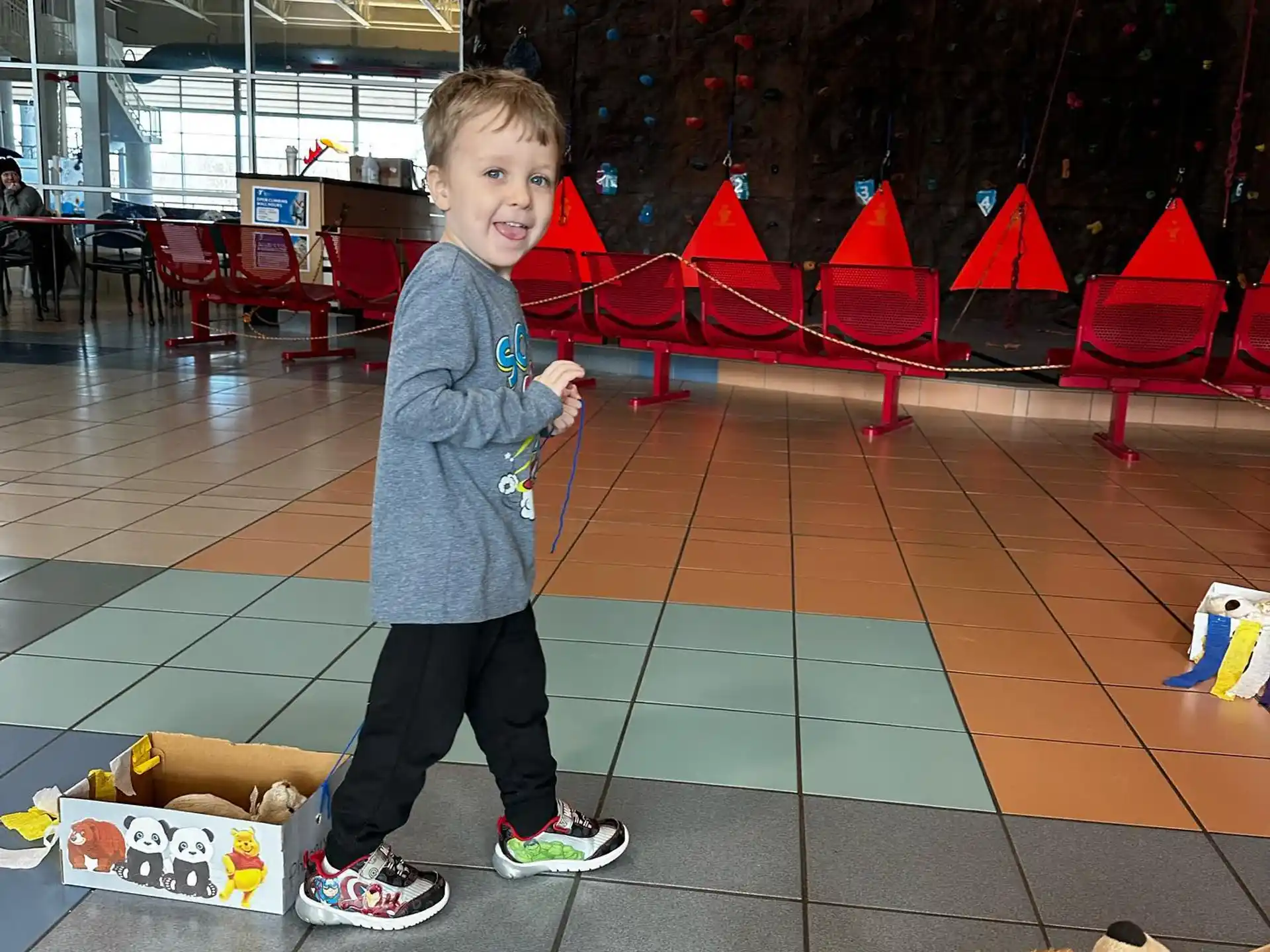 a boy standing on a tile floor