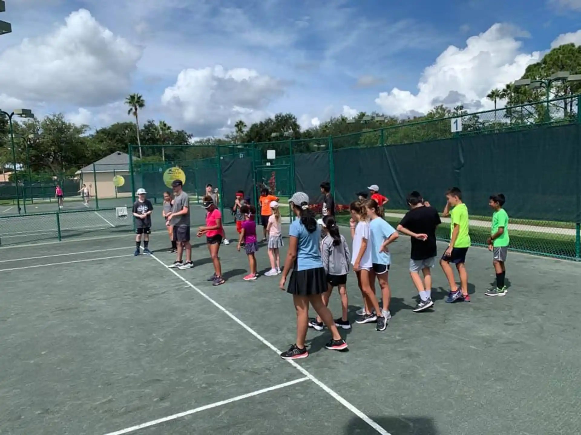 a group of people on a tennis court