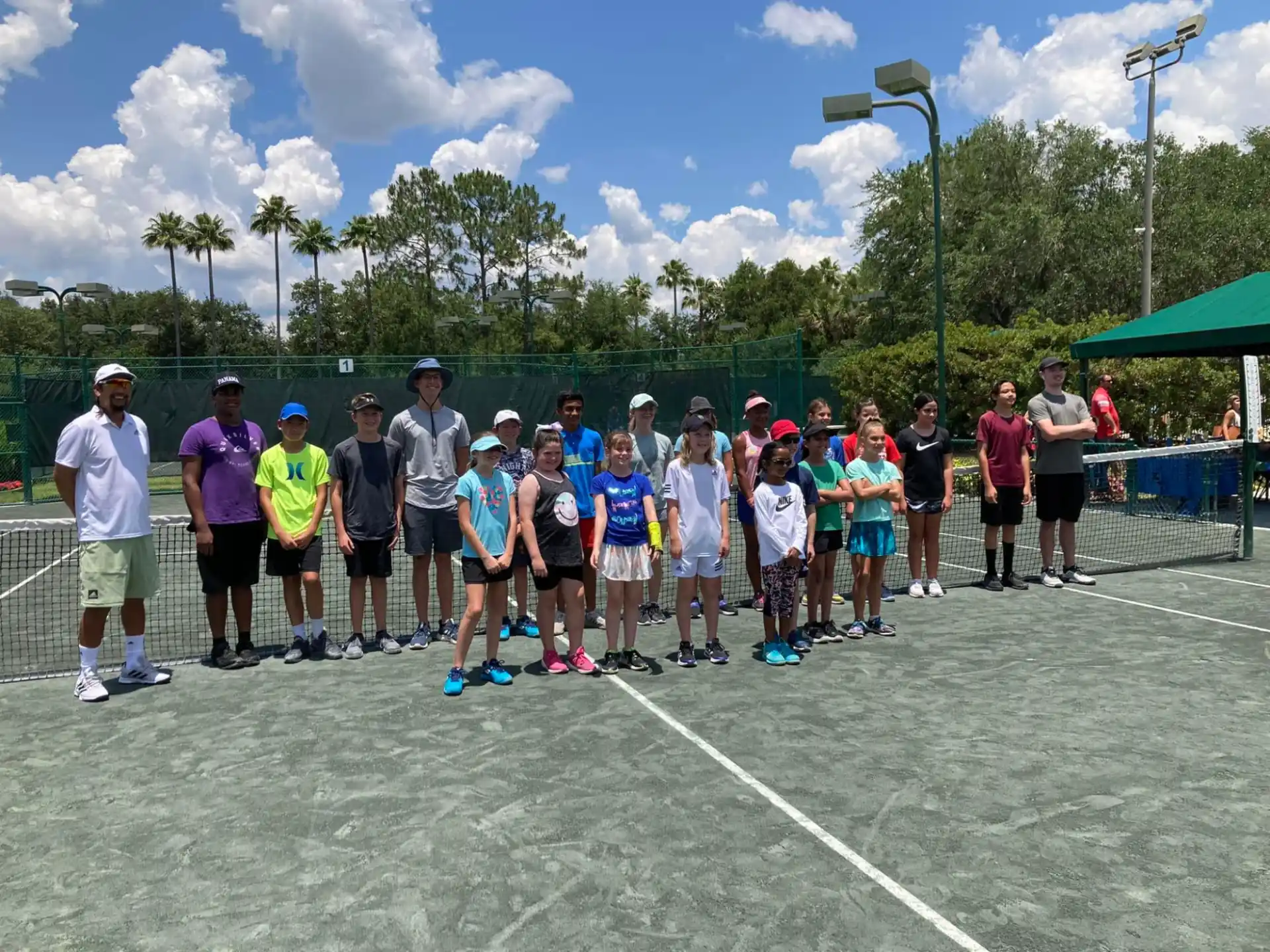 a group of people standing on a tennis court
