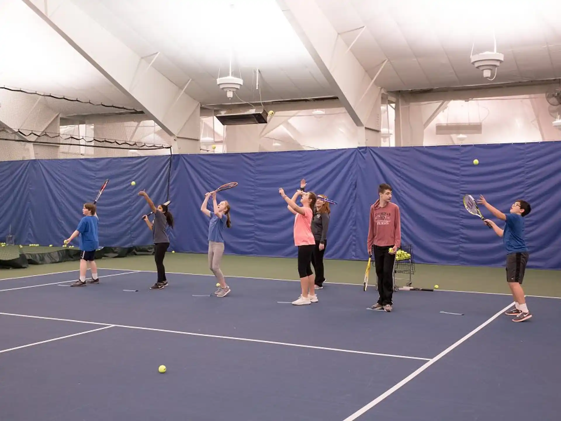 a group of people playing tennis