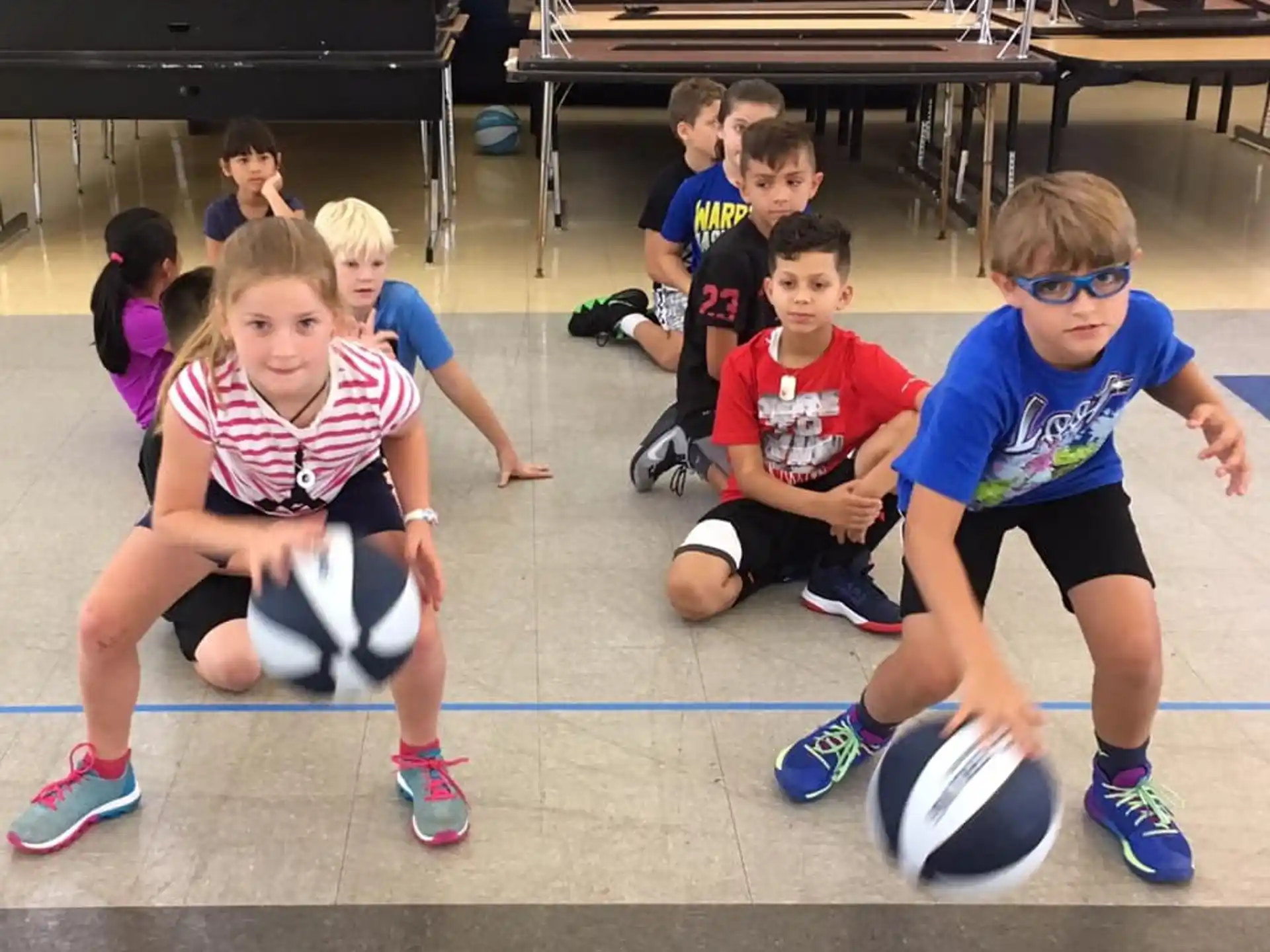 a group of kids sitting on the floor with a football ball