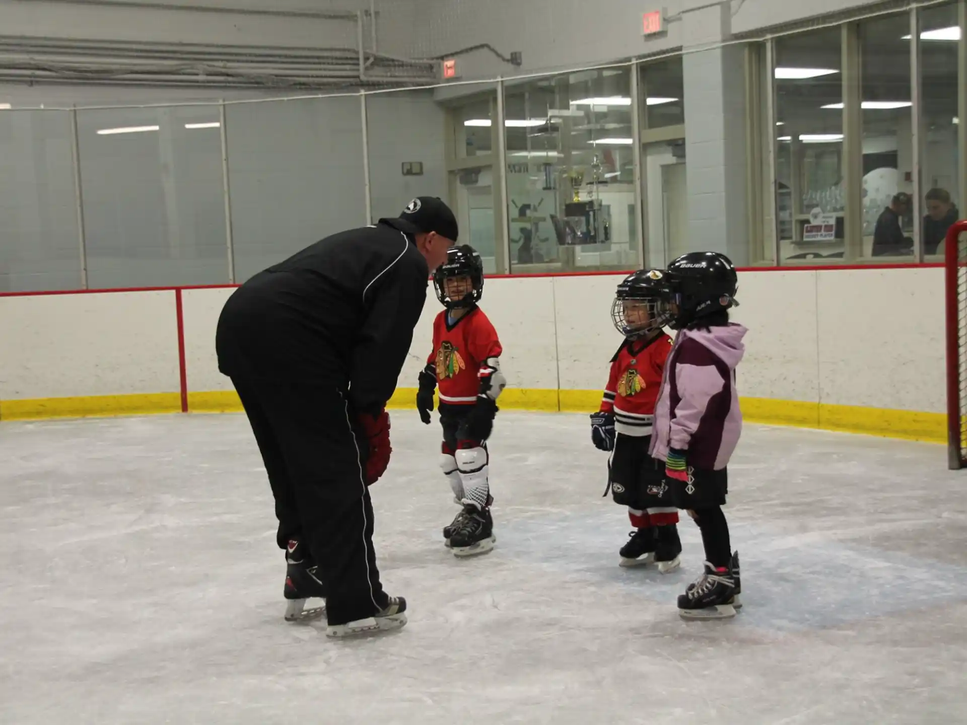 a person and kids playing ice hockey