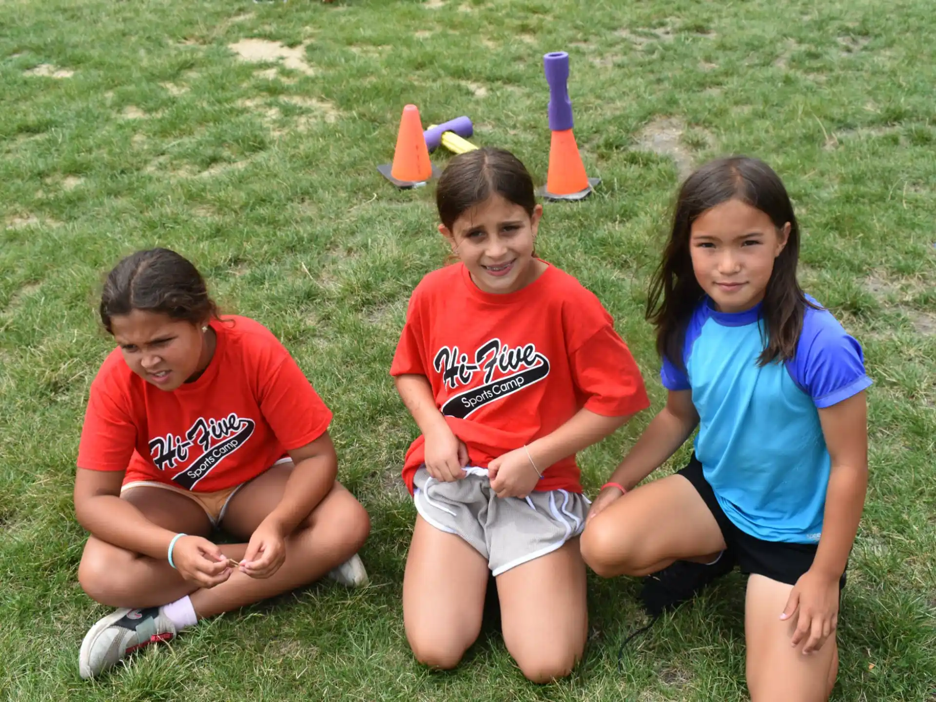 a group of kids sitting on the grass