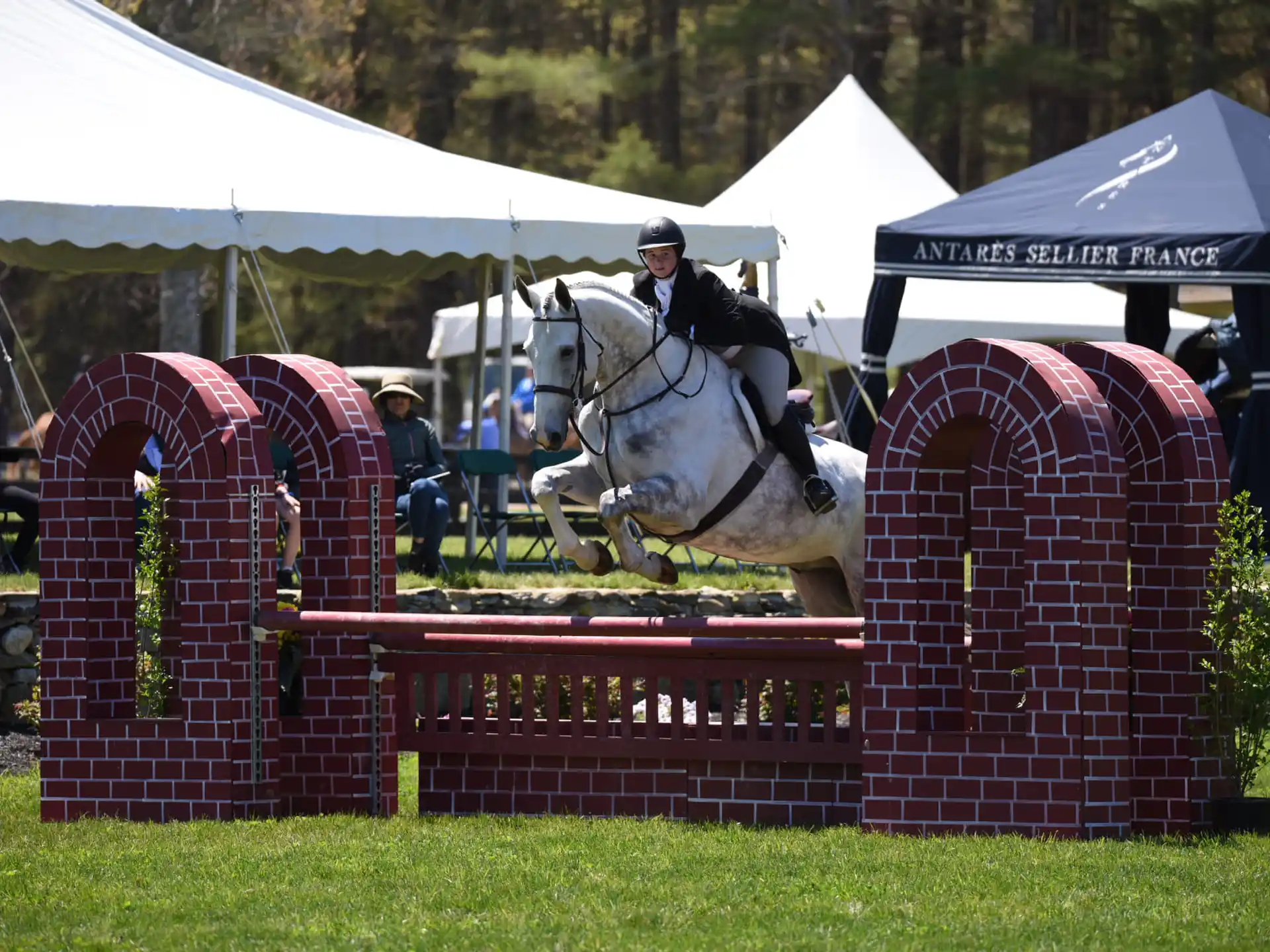a person riding a horse over a jump