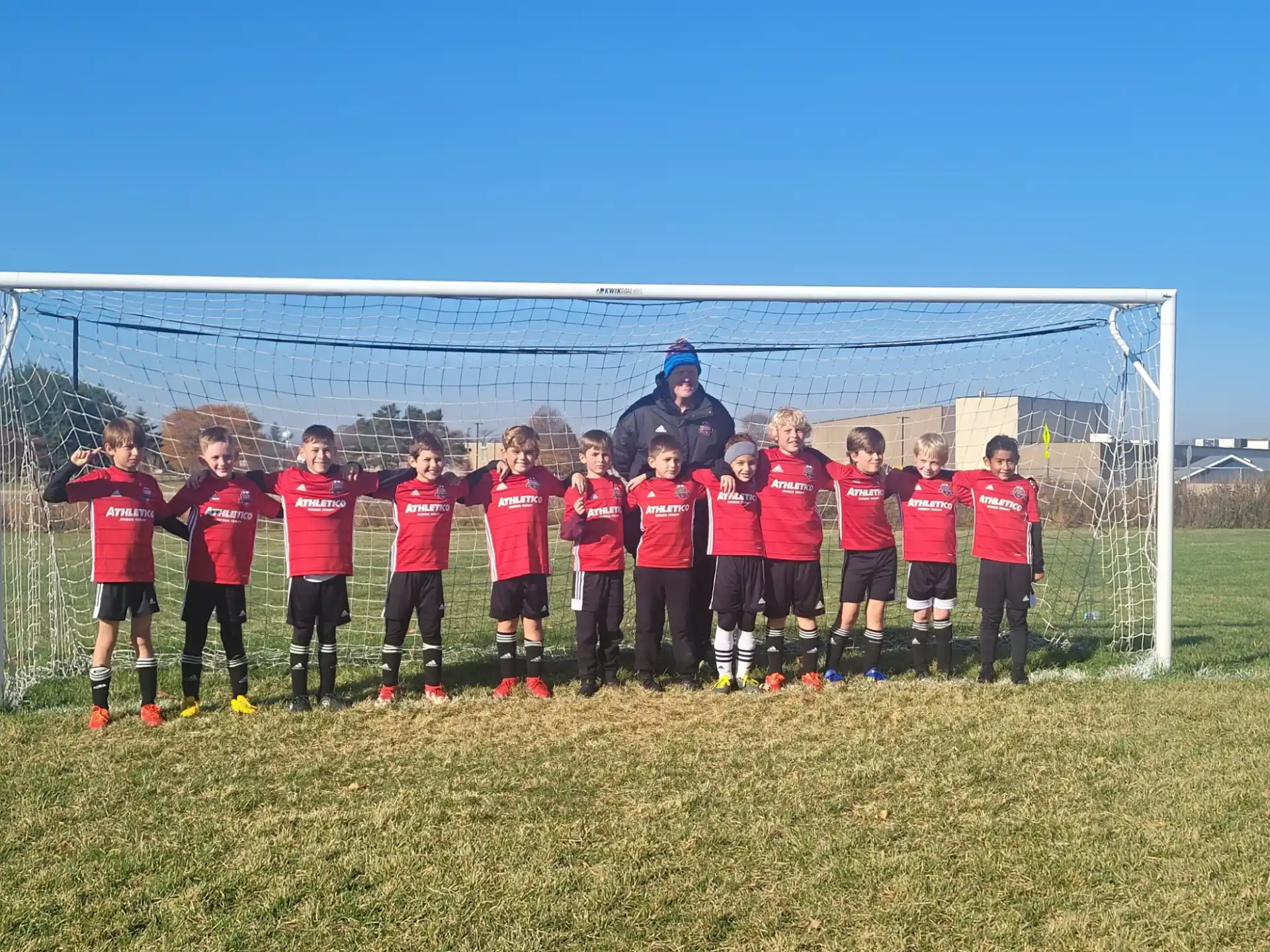 a group of people in red uniforms standing in front of a goal