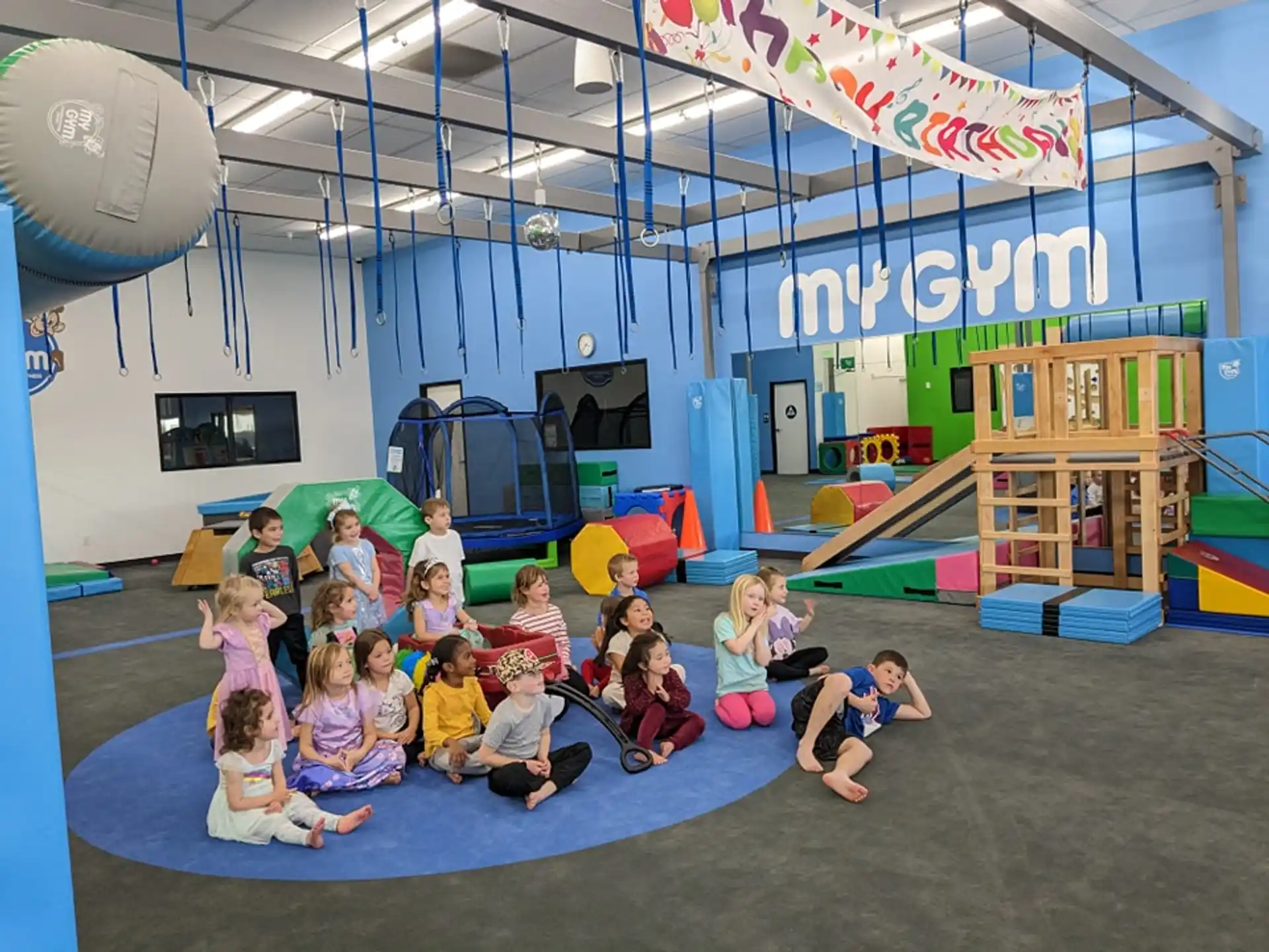 a group of children posing for a photo in a room with a stage
