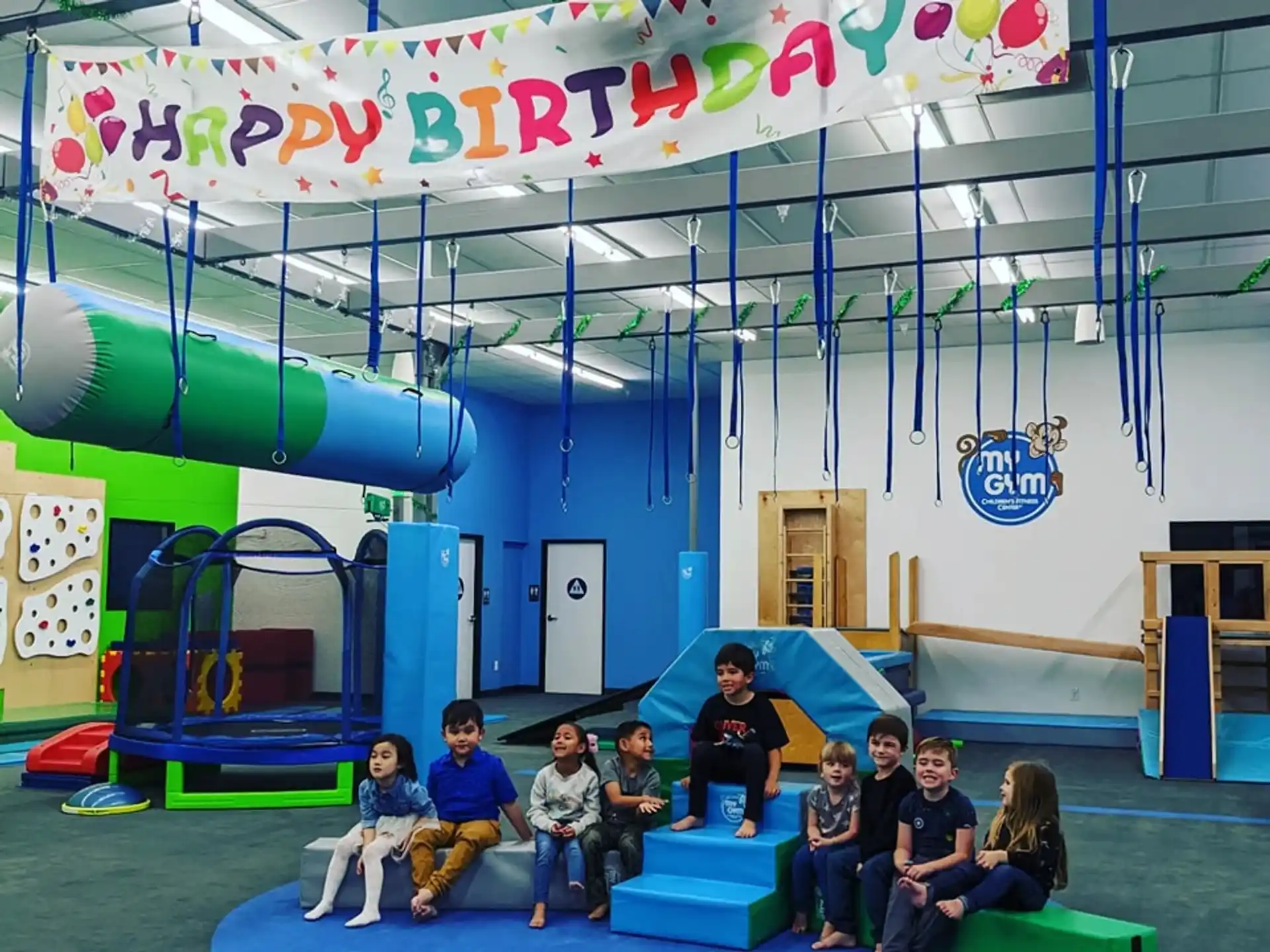 a group of people sitting on a bench in a room with a slide