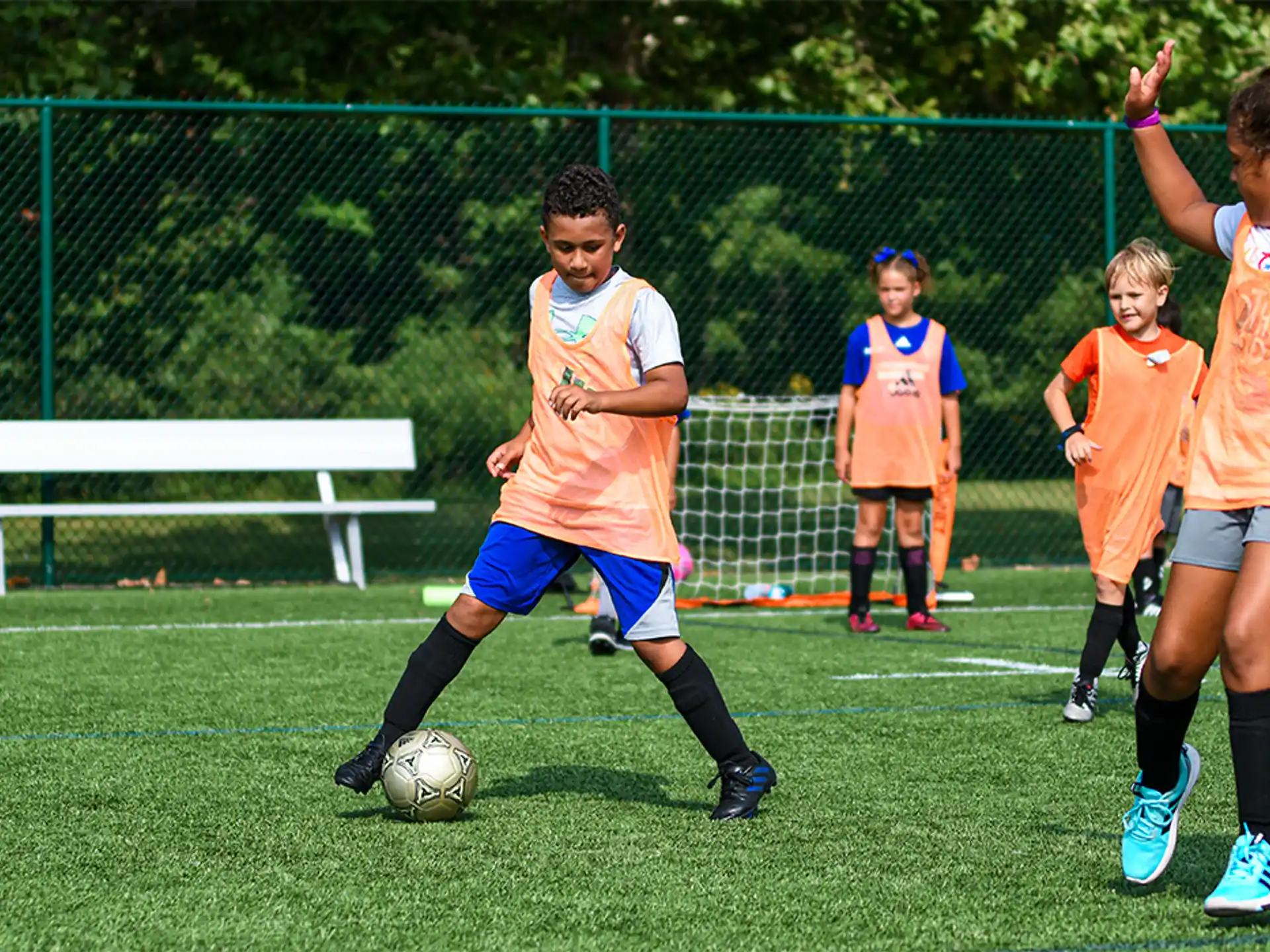 a group of kids compete over a football ball
