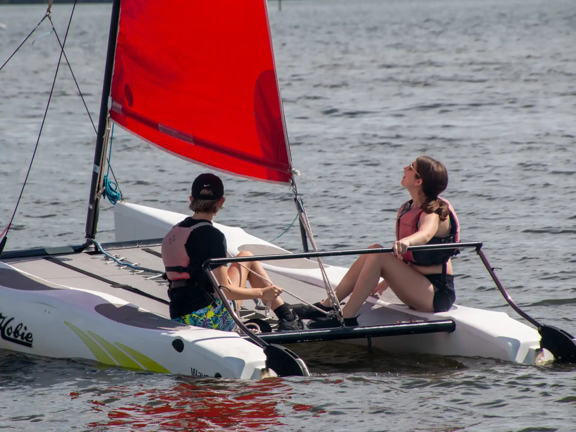 a man and a woman on a sailboat in the water