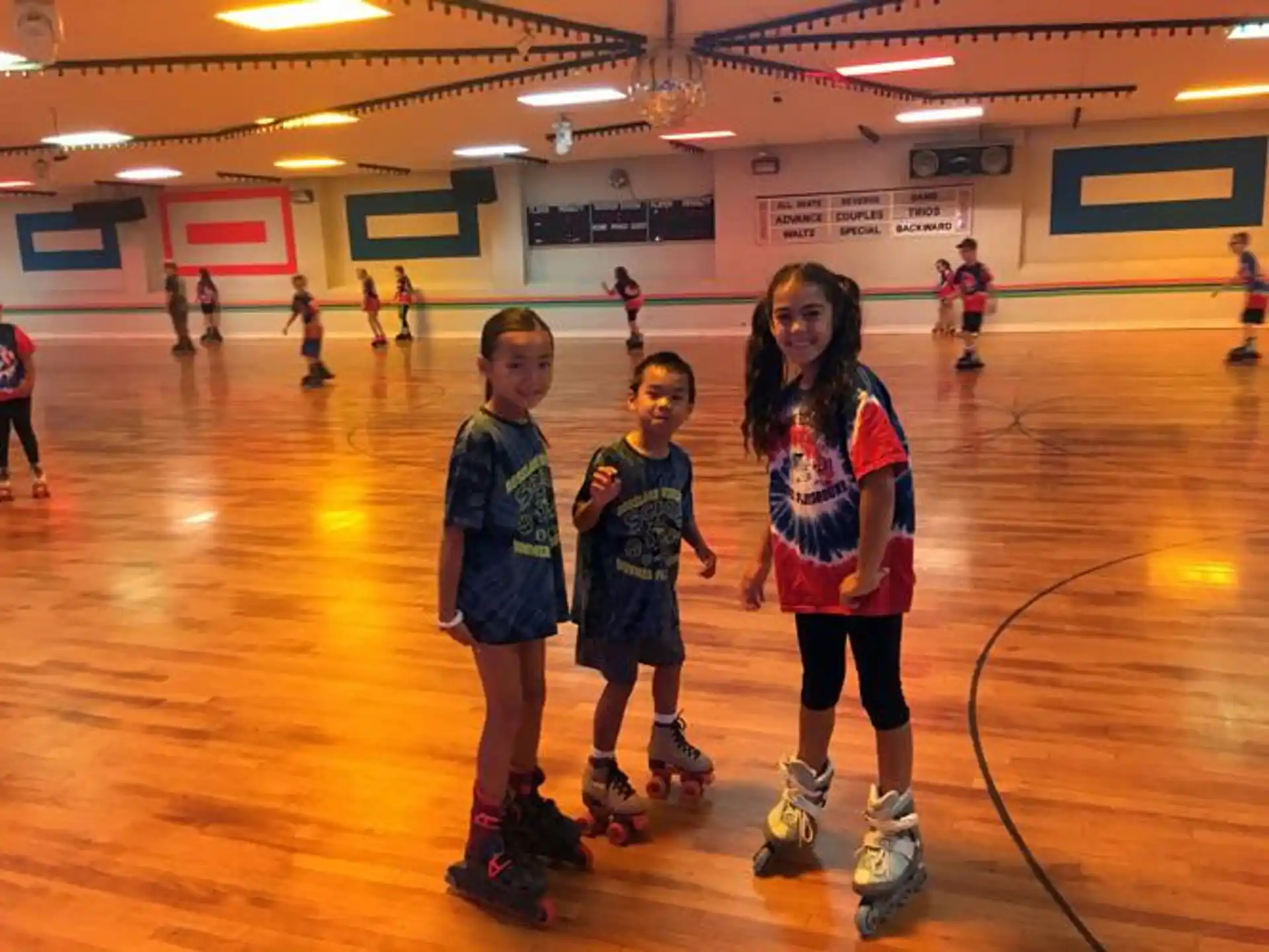 a group of children wearing roller skates in a gym