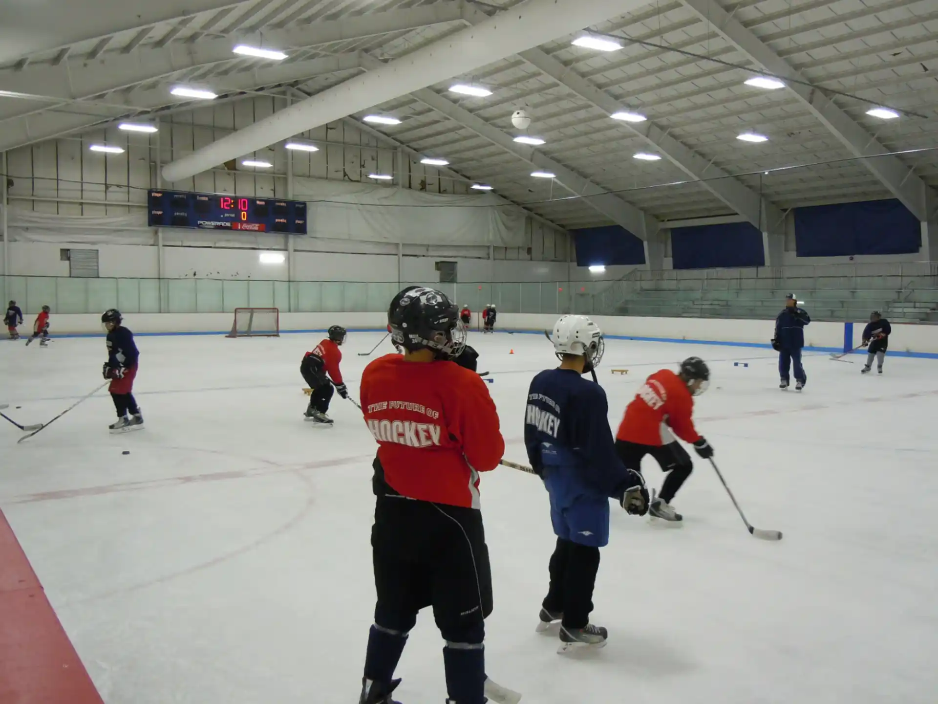 a group of people on an ice rink with hockey sticks