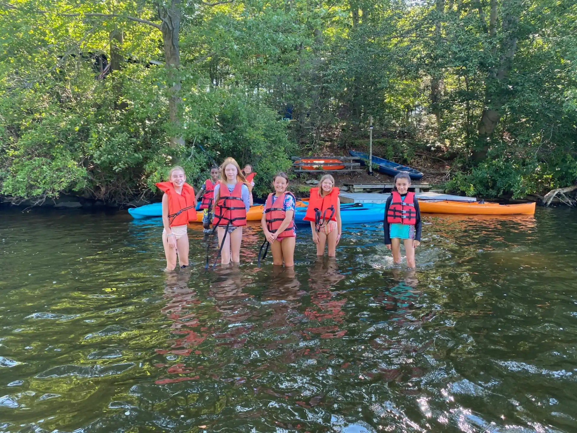 a group of people in life jackets standing in a river